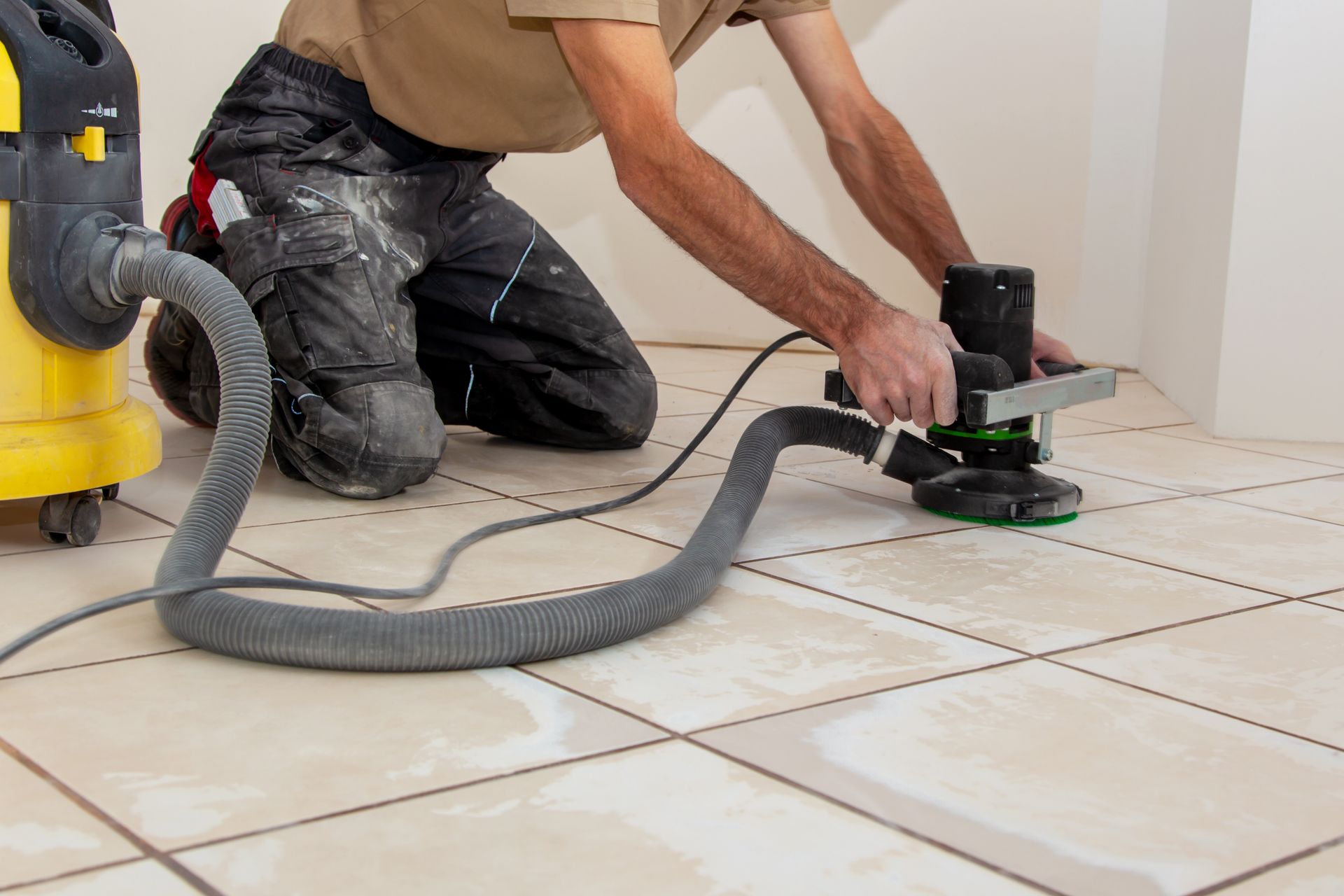 Sol époxy gris brillant dans un espace lumineux et vide de type garage avec une porte enroulable.