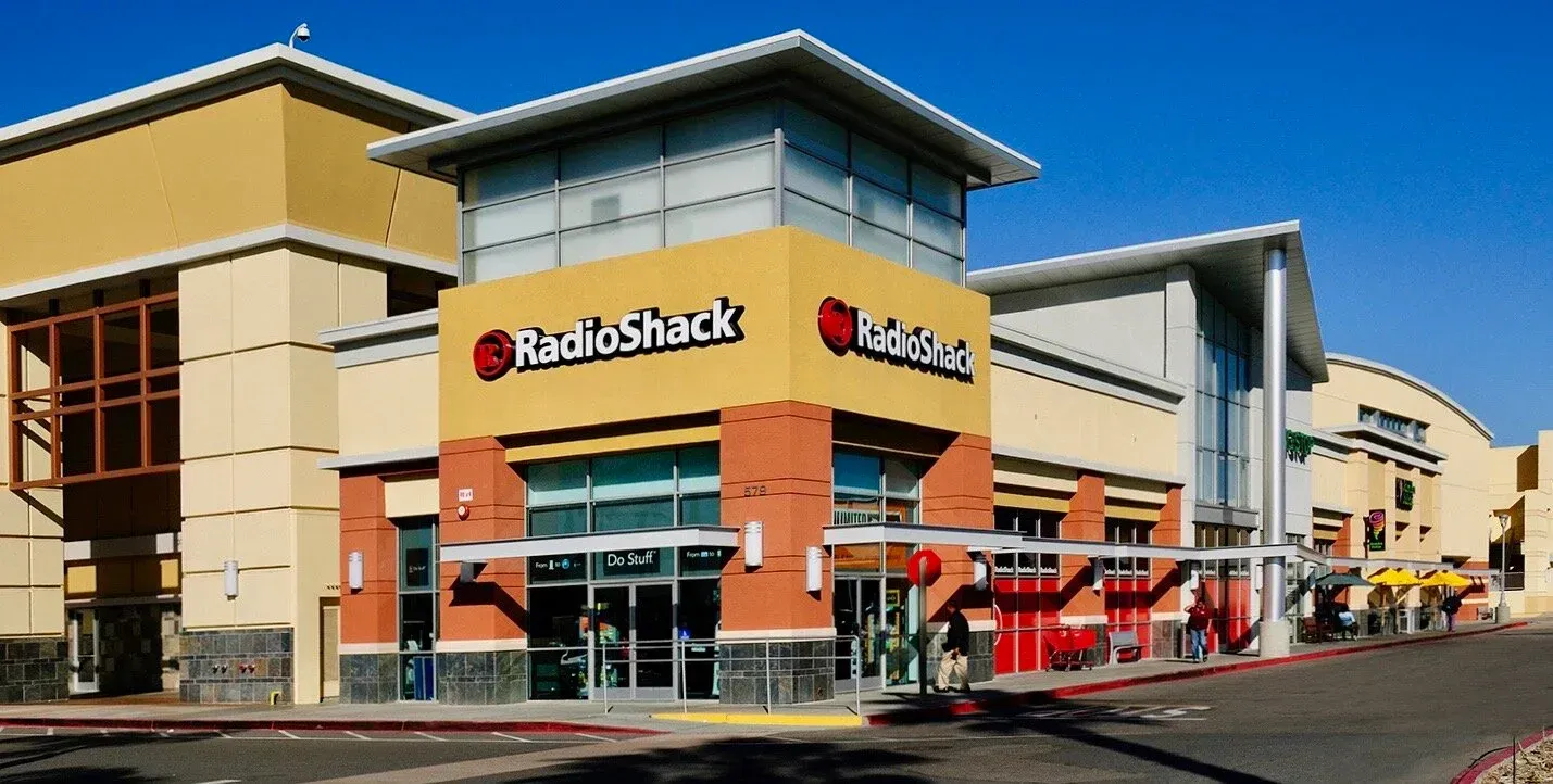 Modern two-story building with cars parked in front and American flag.