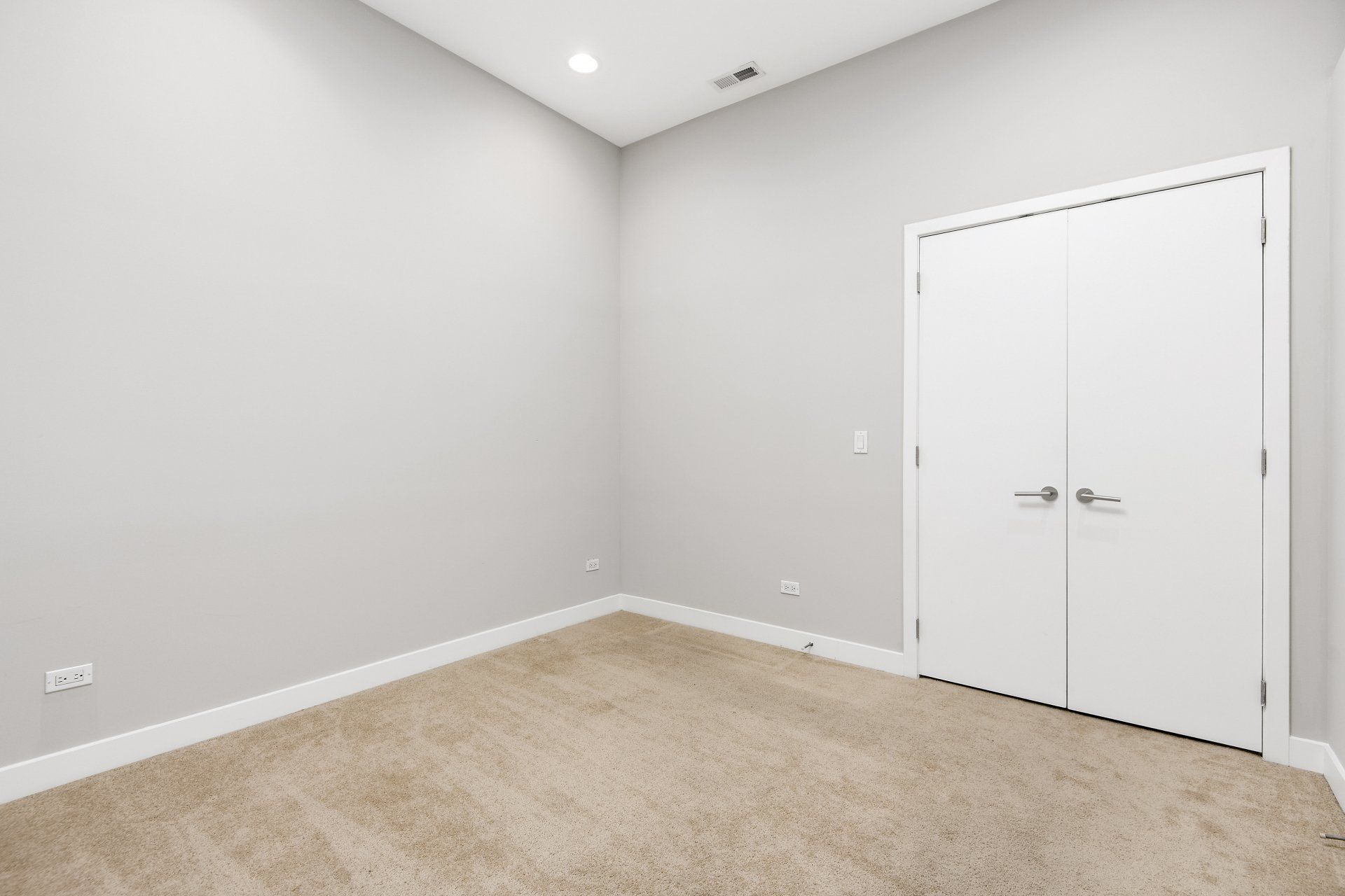 An empty room with a carpeted floor and a white door at 1846 W Division Street.