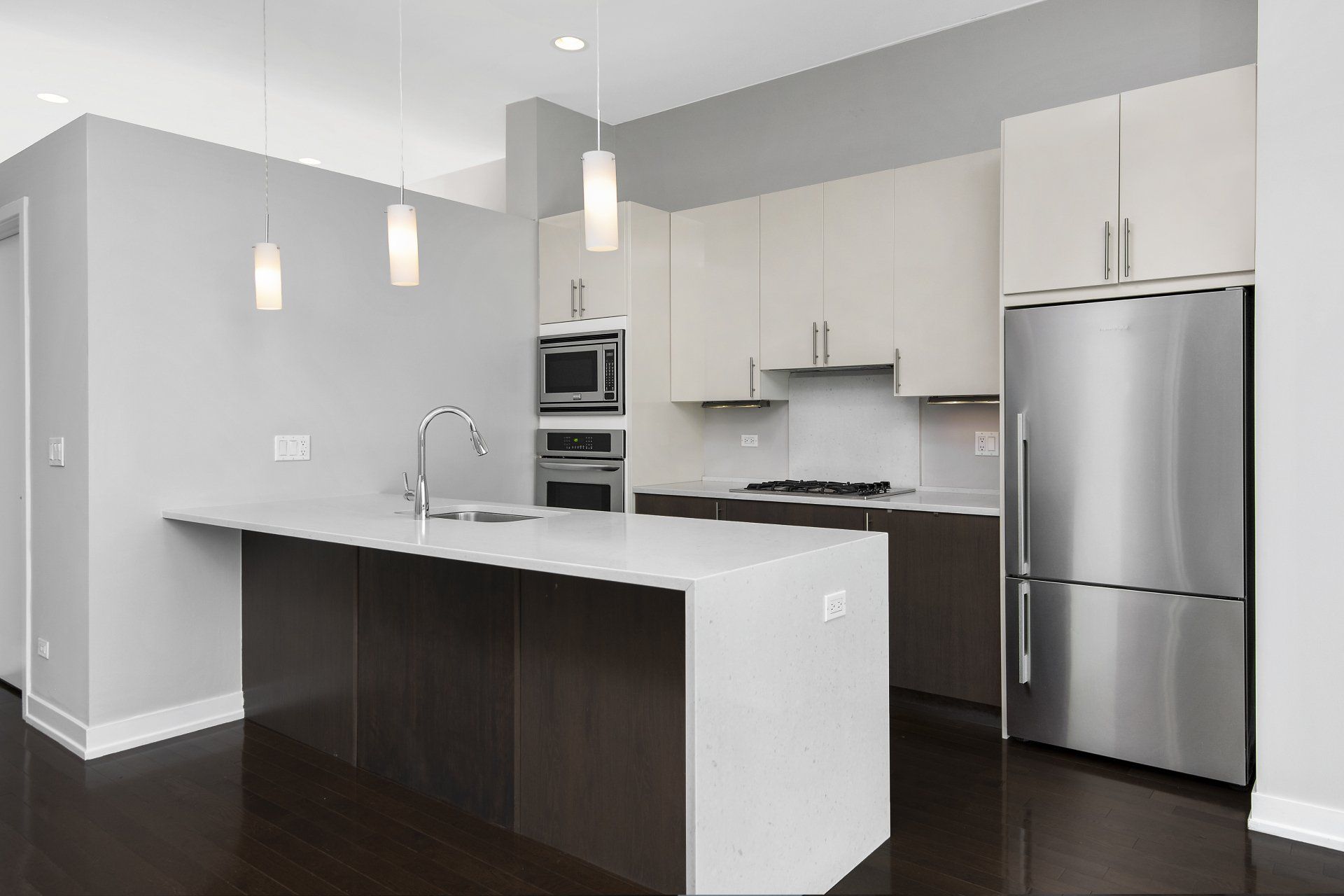 Apartment kitchen with stainless steel appliances and white cabinets at 1846 W Division Street.