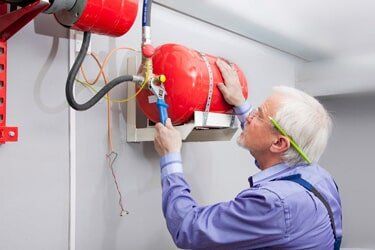 Man fixing fire extinguisher  — Fire extinguisher service in Bakersfield, CA