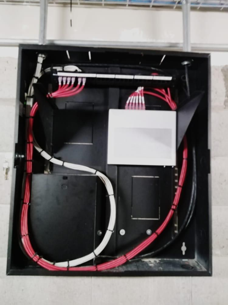 Una caja negra con cables rojos y blancos que salen de ella