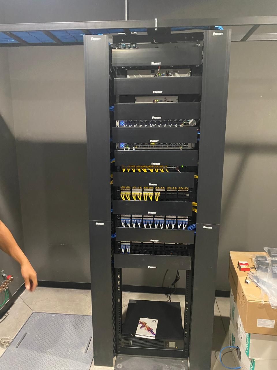 Un hombre está parado frente a un rack de servidores.