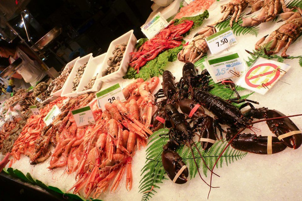 banco di una pescheria con scampi e astici