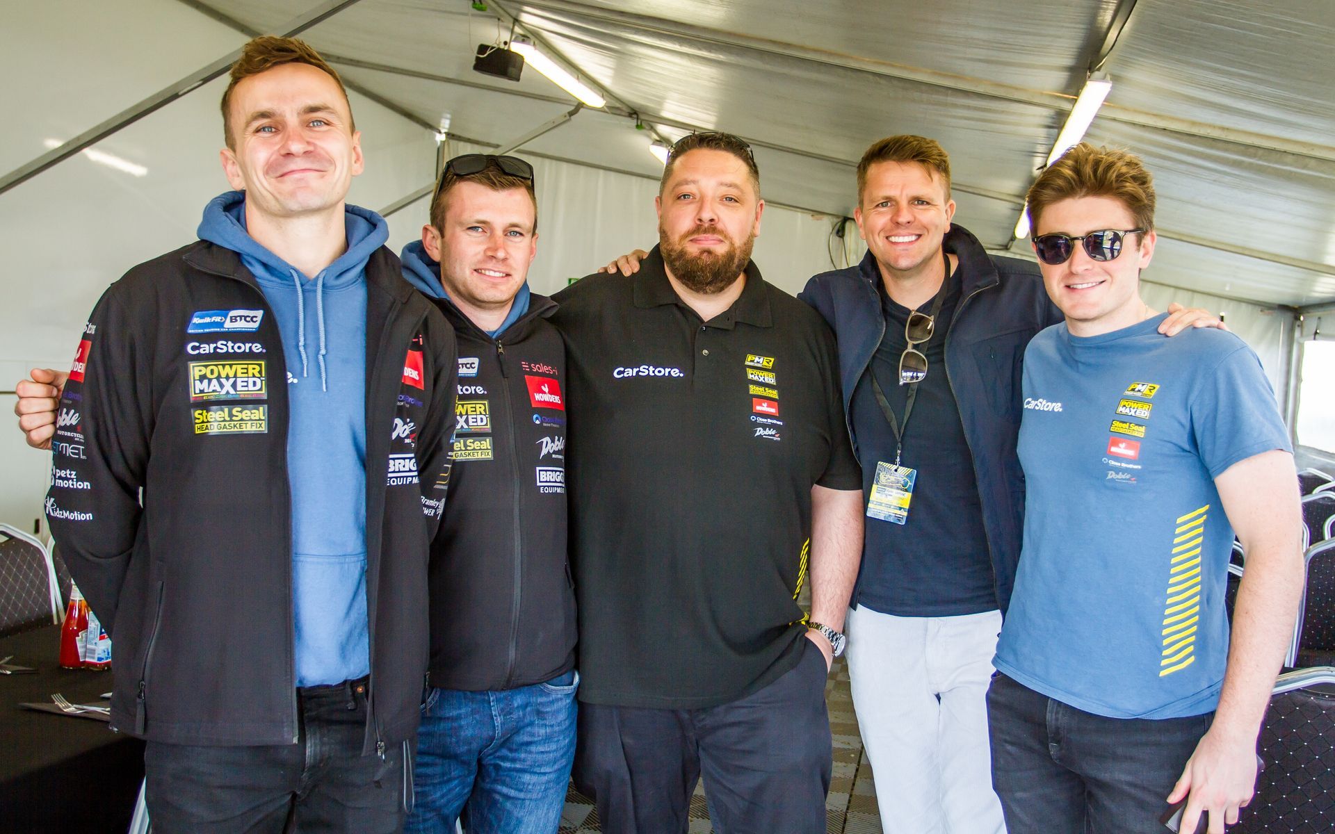 A group of young men are posing for a picture in a tent.