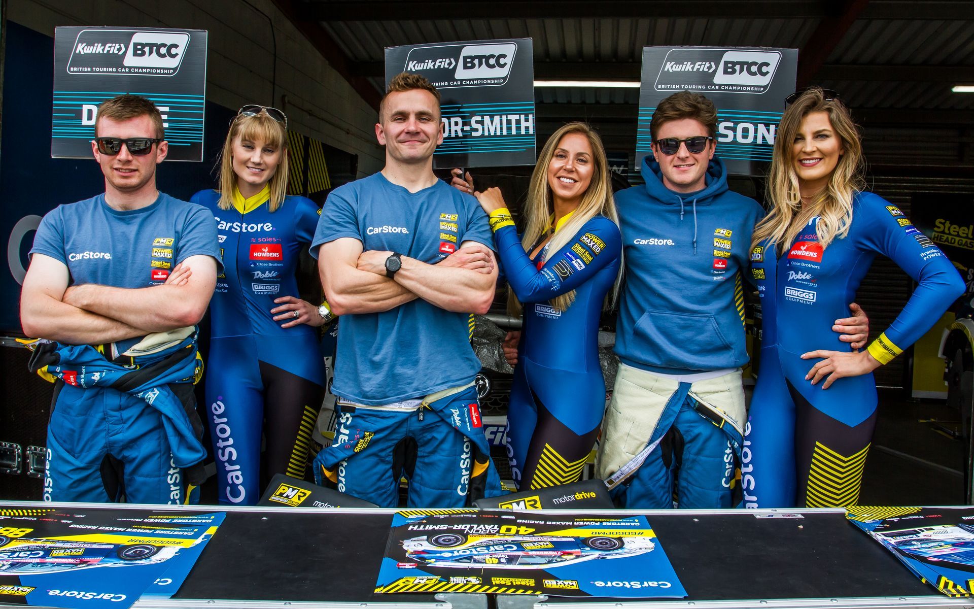 A group of people standing next to each other with their arms crossed.