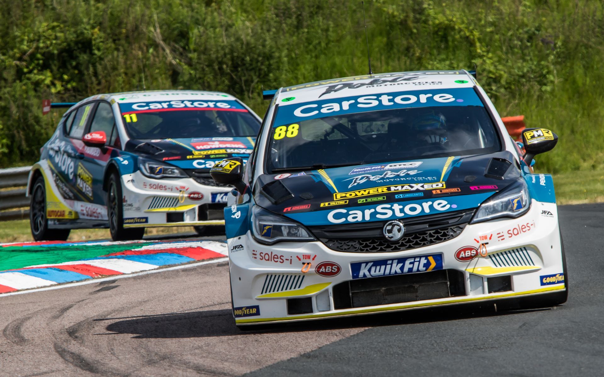 Two race cars are racing on a race track.