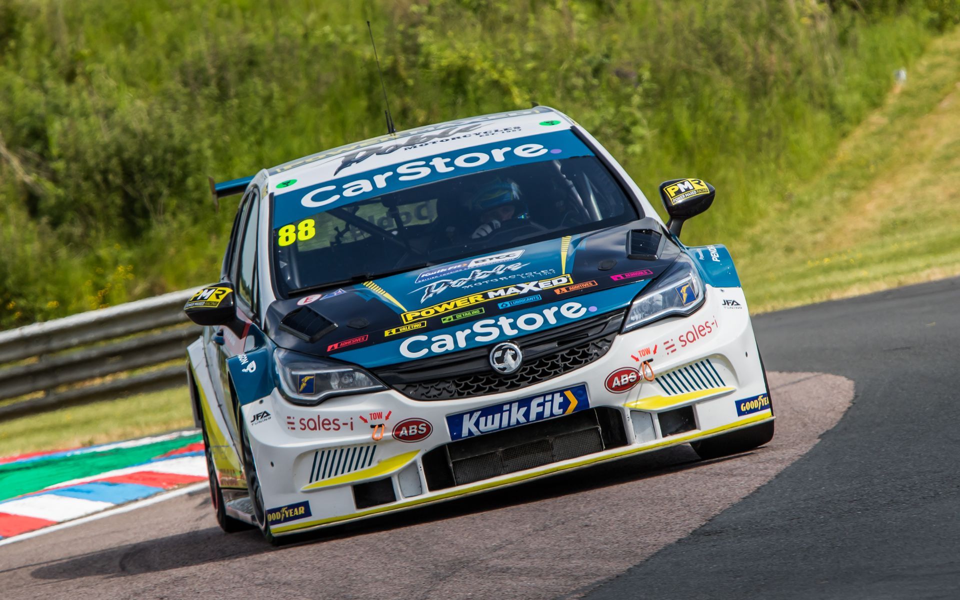 A race car is driving down a race track.