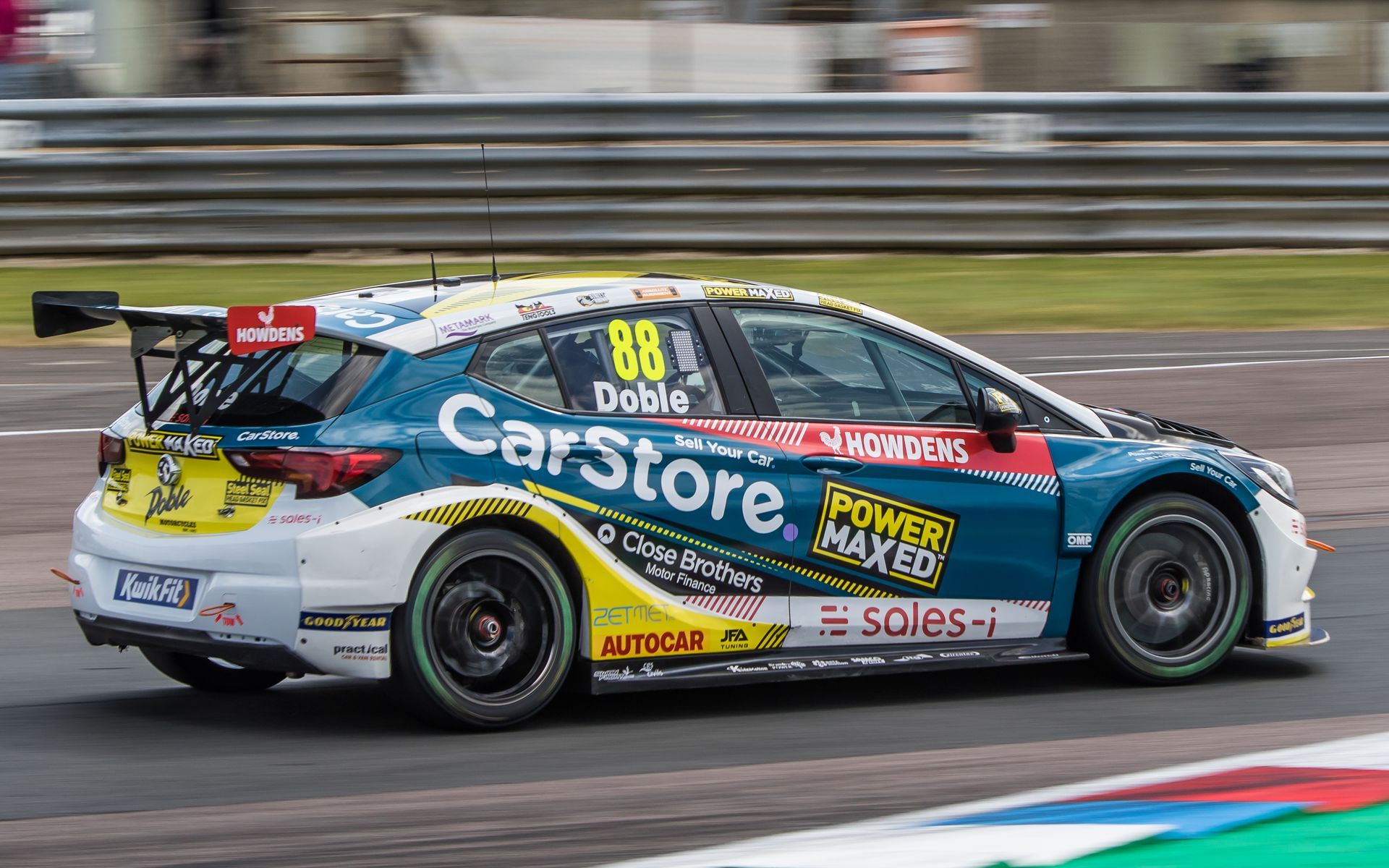 A race car is driving down a race track.