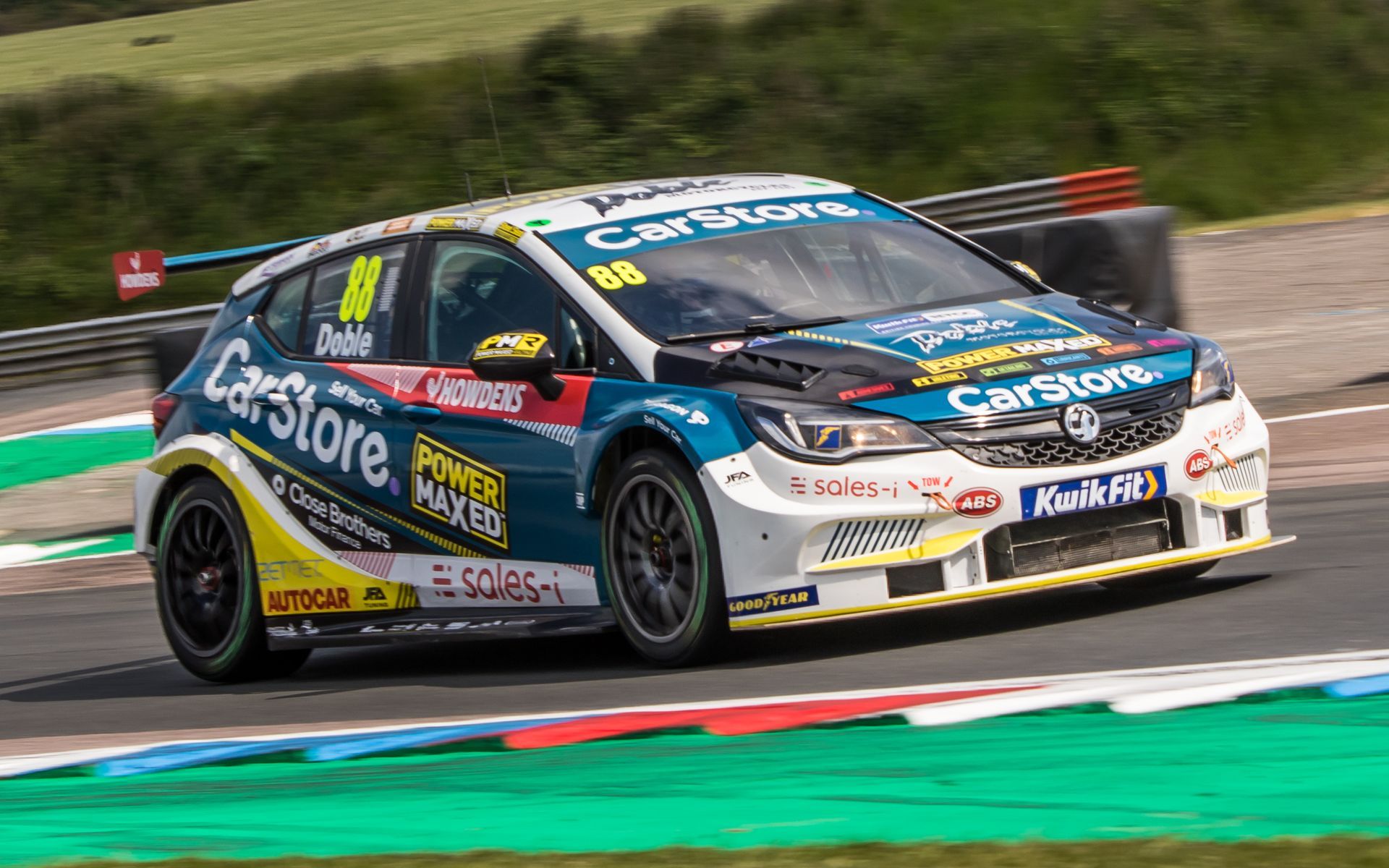 A race car is driving down a race track.