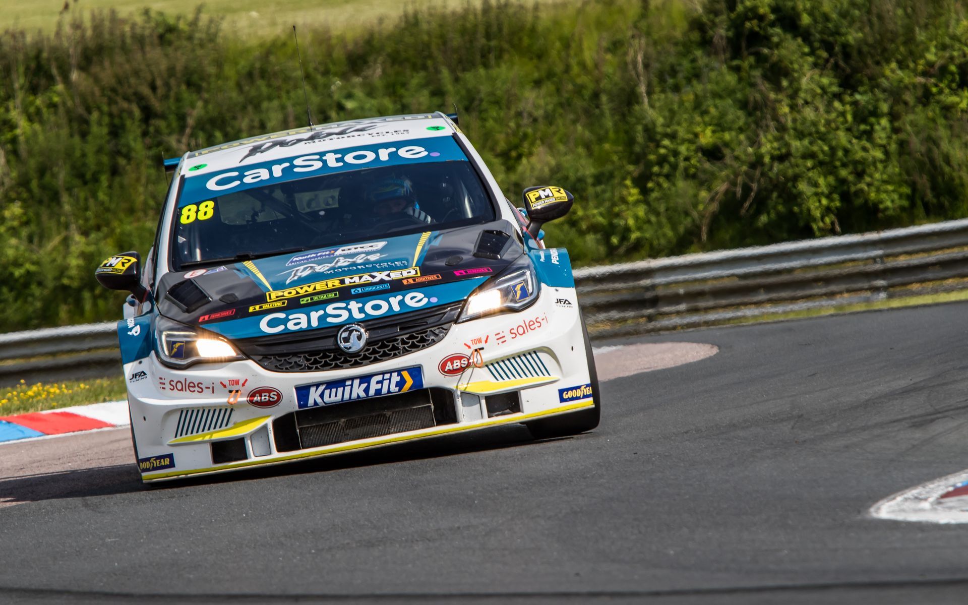 A race car is driving down a race track.