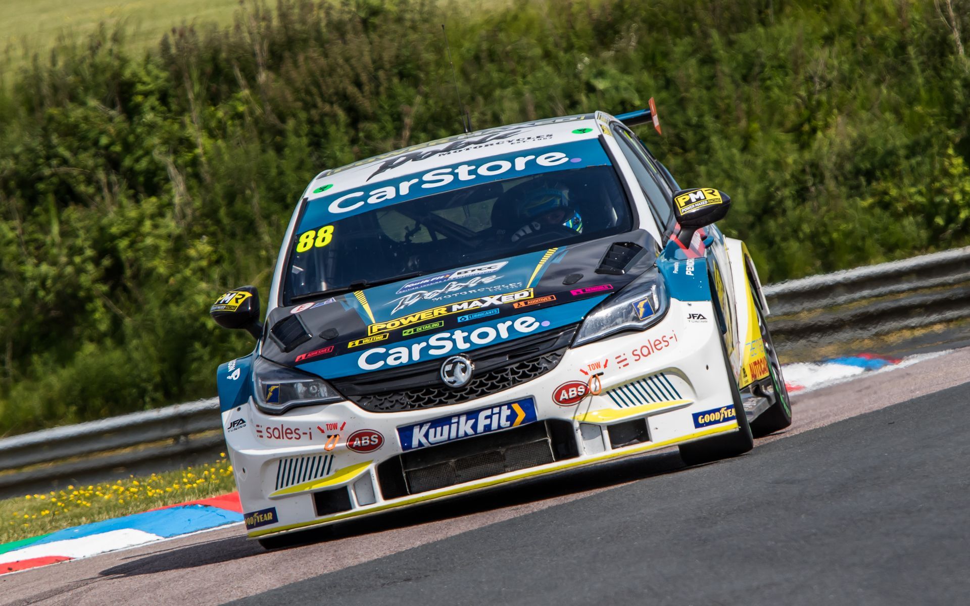 A racing car is driving down a race track.