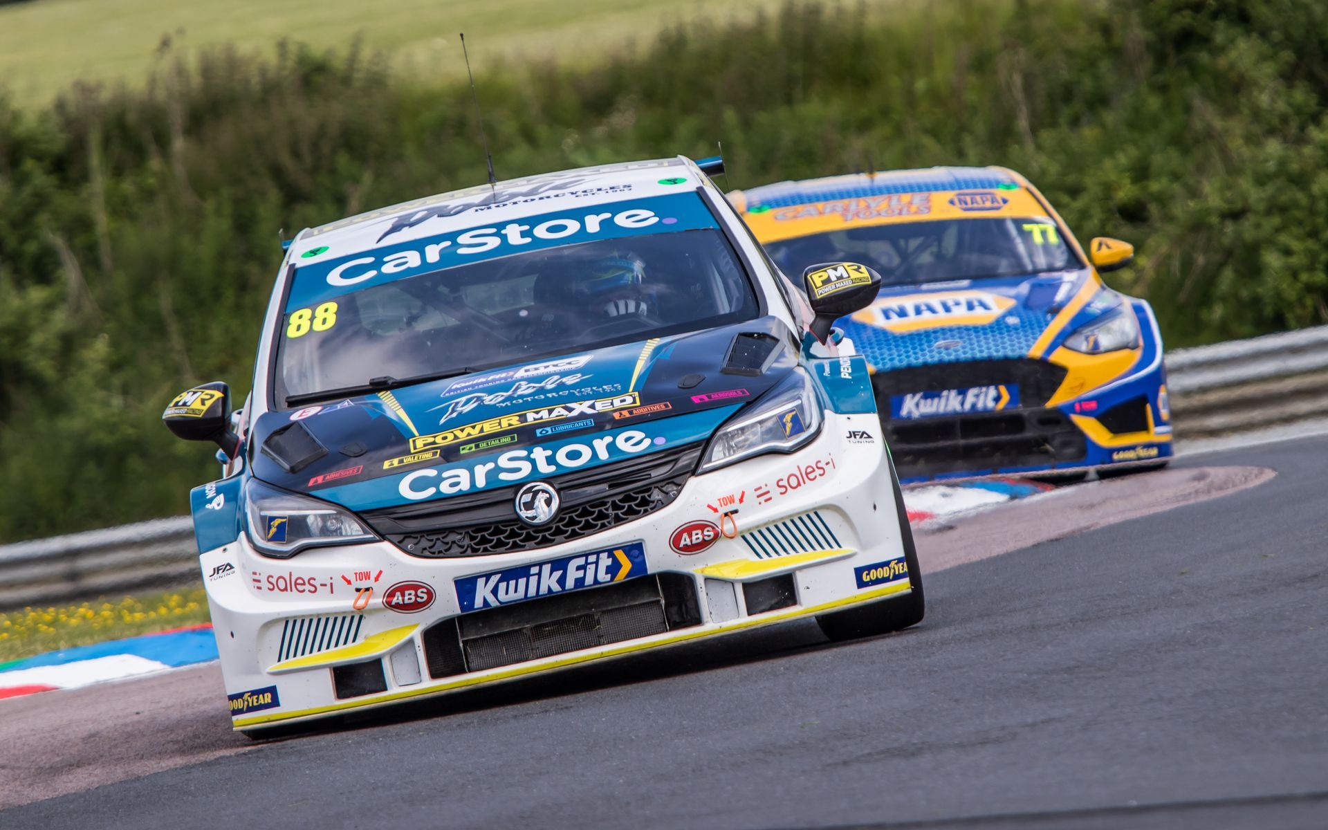 Two race cars are racing on a race track.