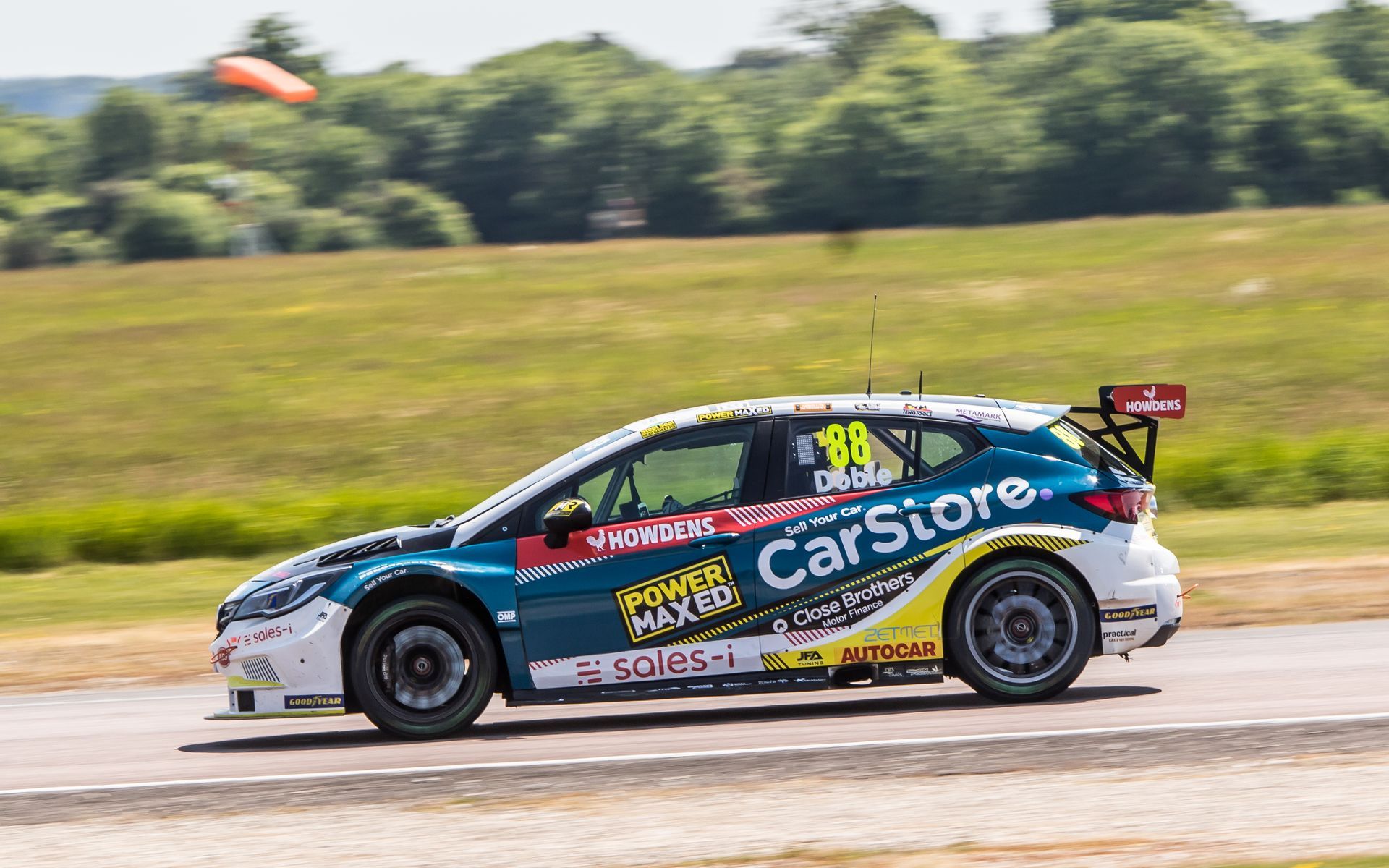 A racing car is driving down a race track.