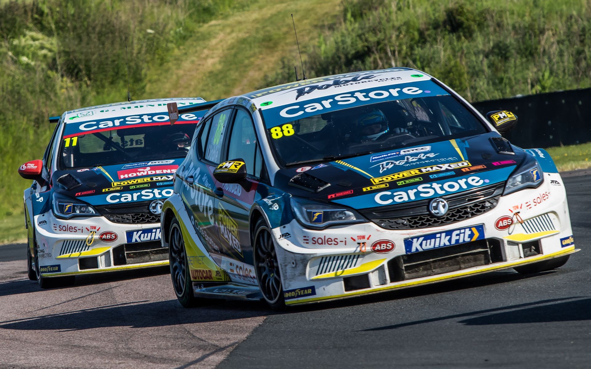 Two race cars are racing on a track.