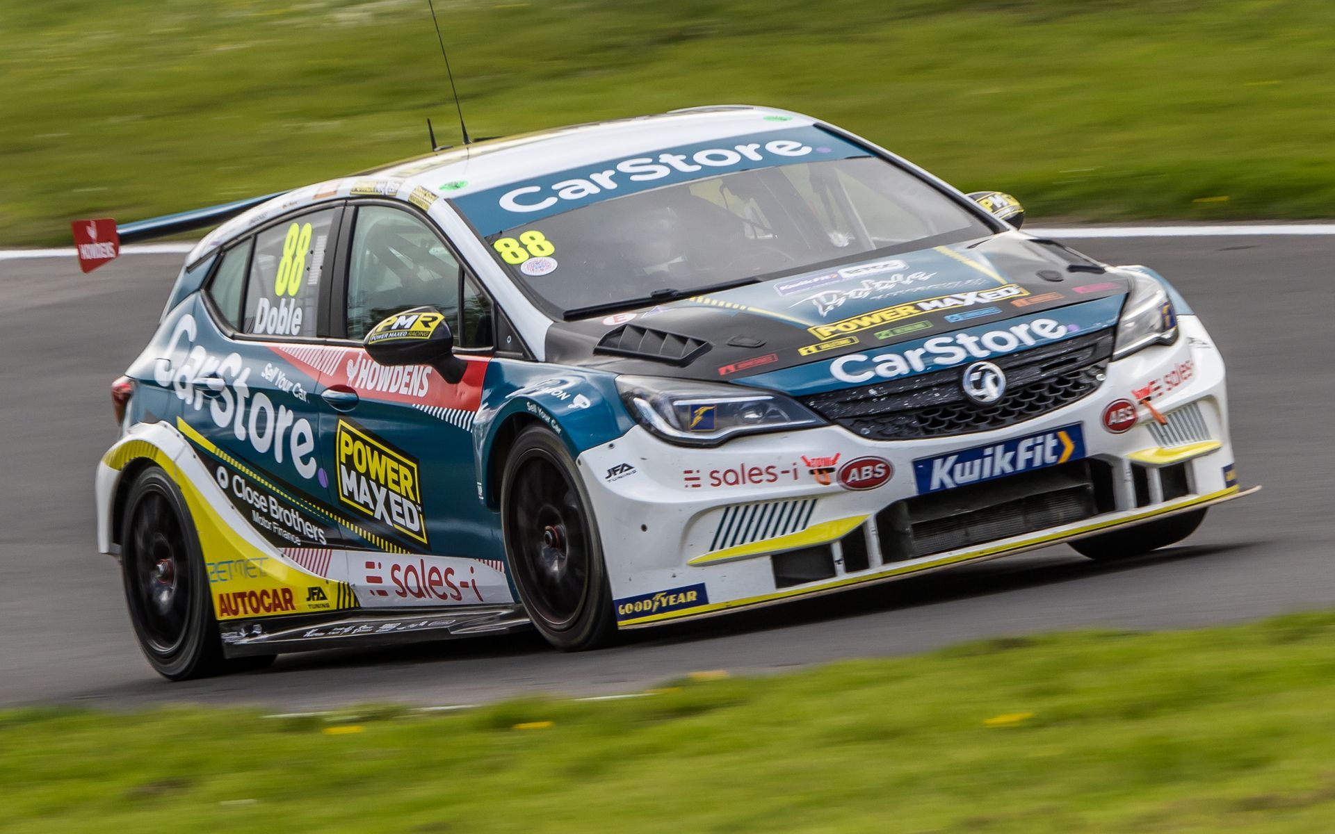 A racing car is driving down a race track.