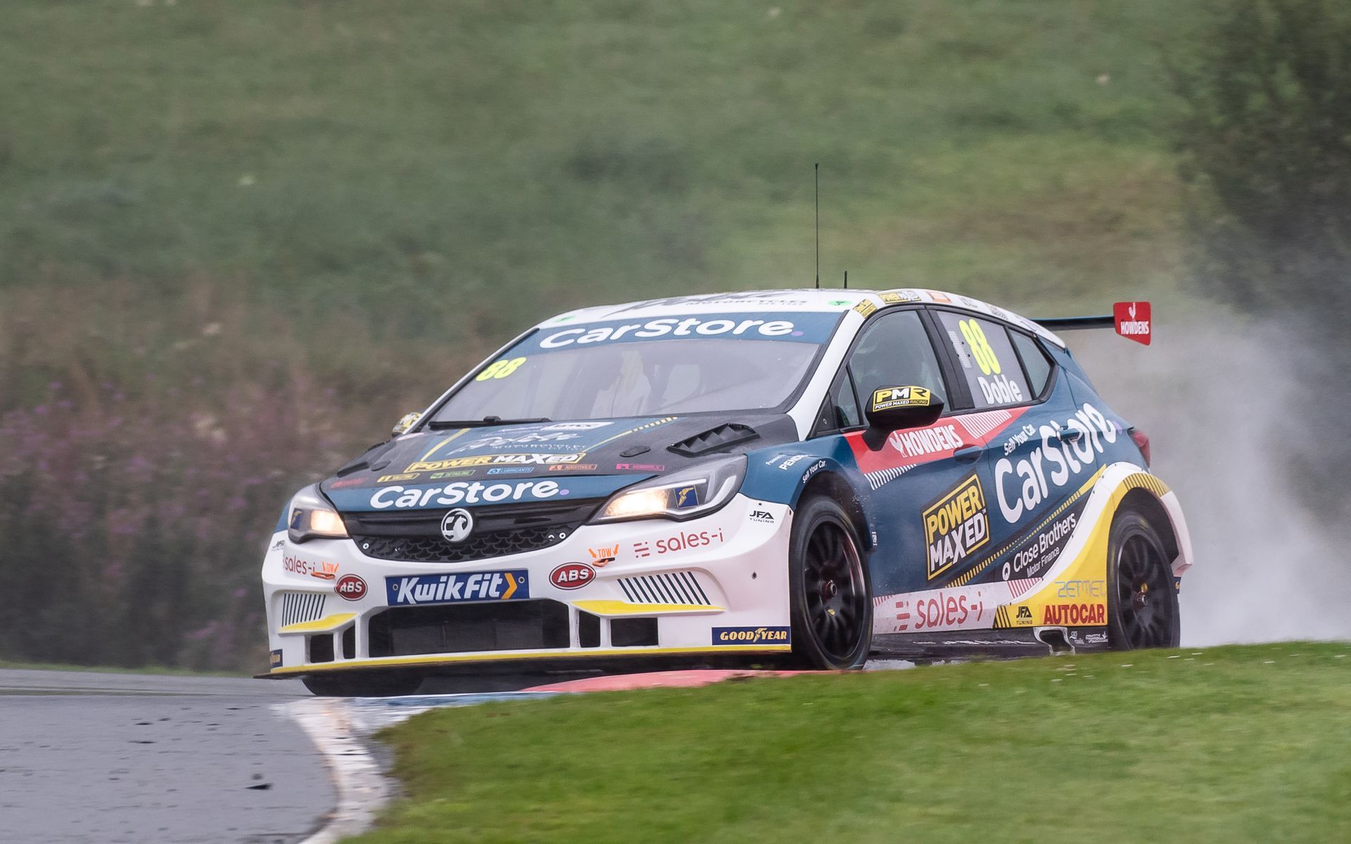 A race car is driving down a grassy hill.