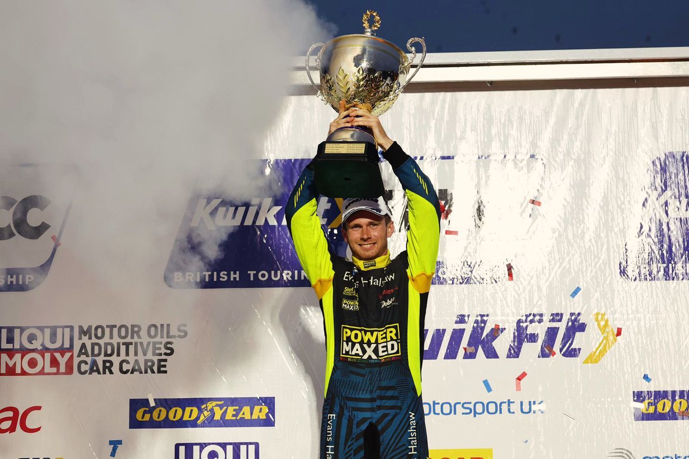 A man is holding a trophy over his head.