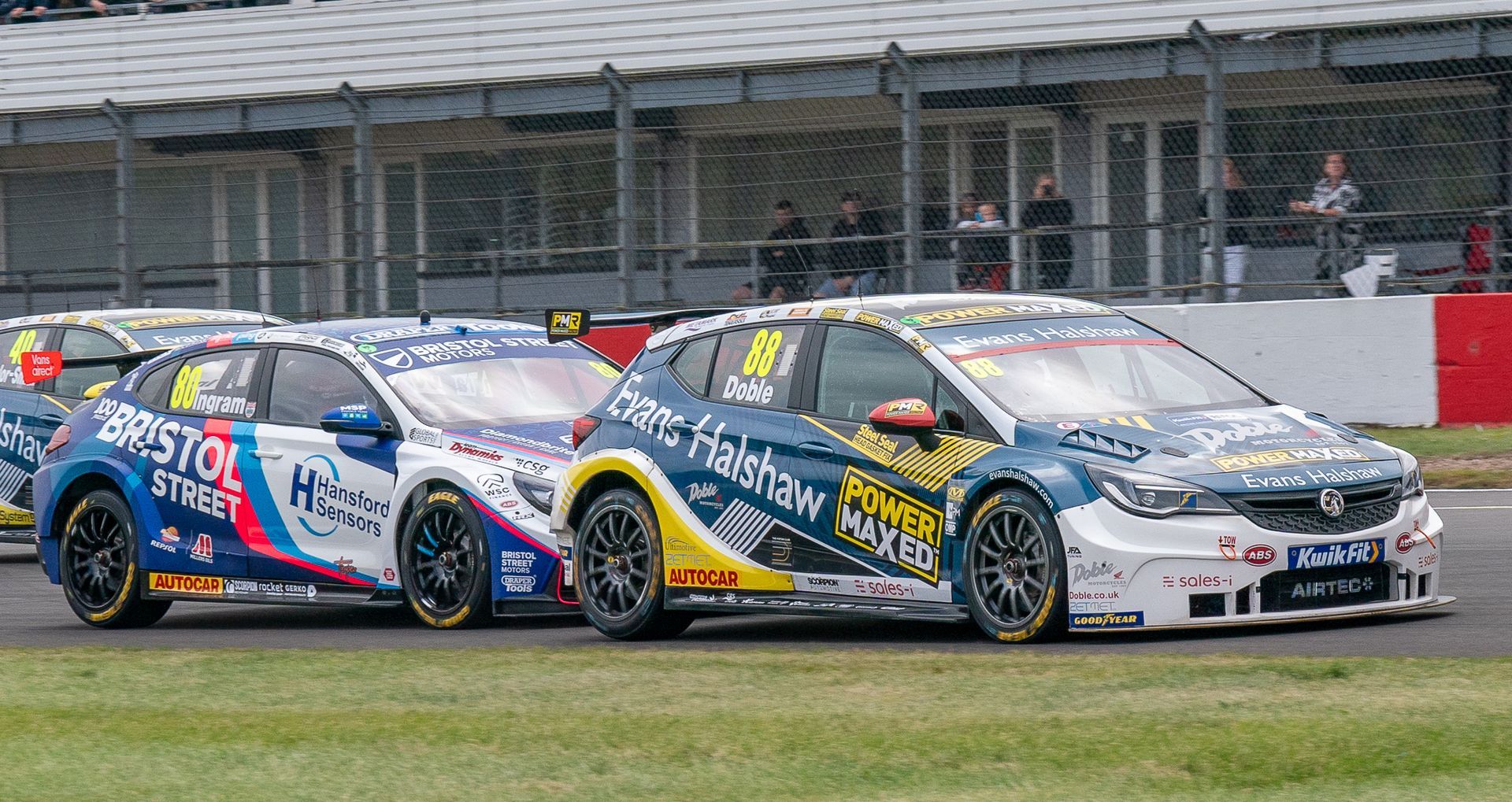 Two racing cars are racing on a race track.