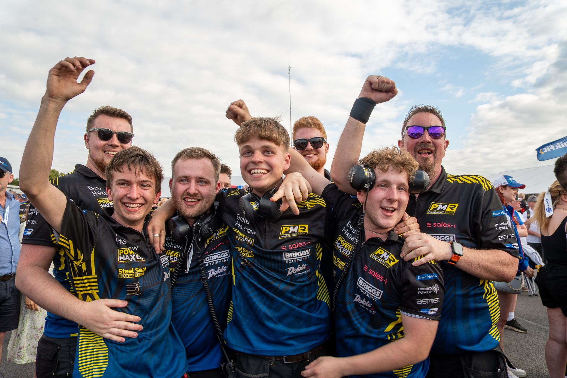 A group of young men are posing for a picture with their arms in the air.