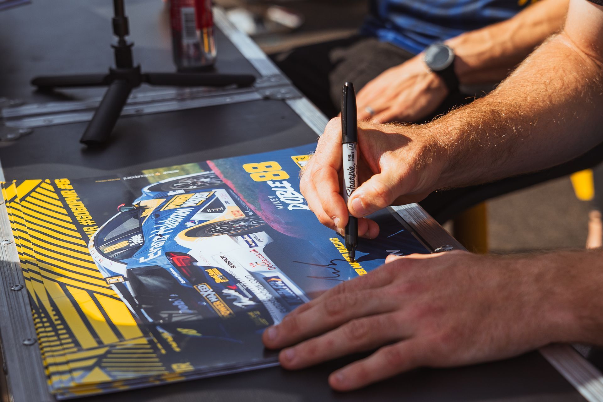 A man is writing on a piece of paper with a marker.