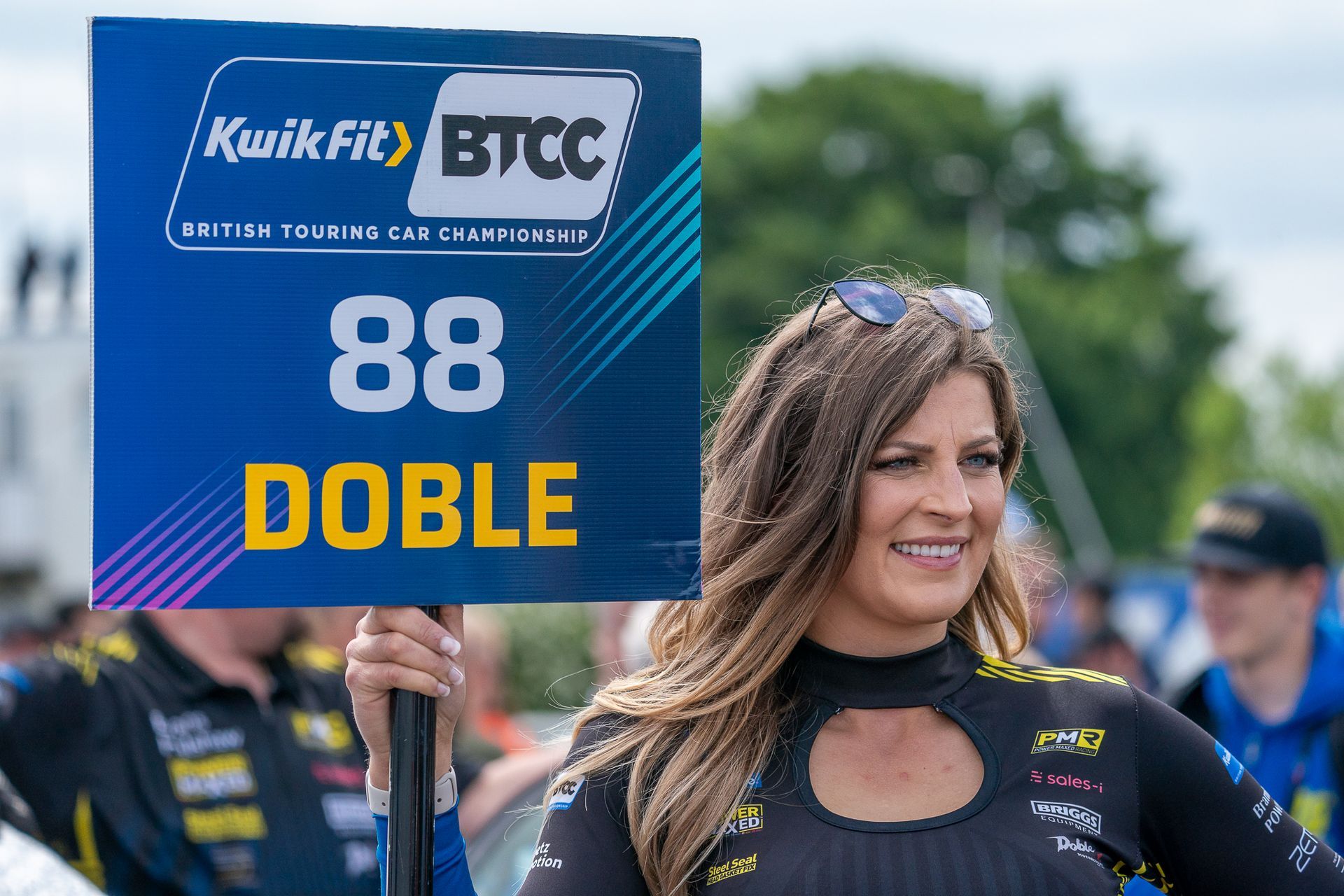 A woman holding a sign that says doble on it