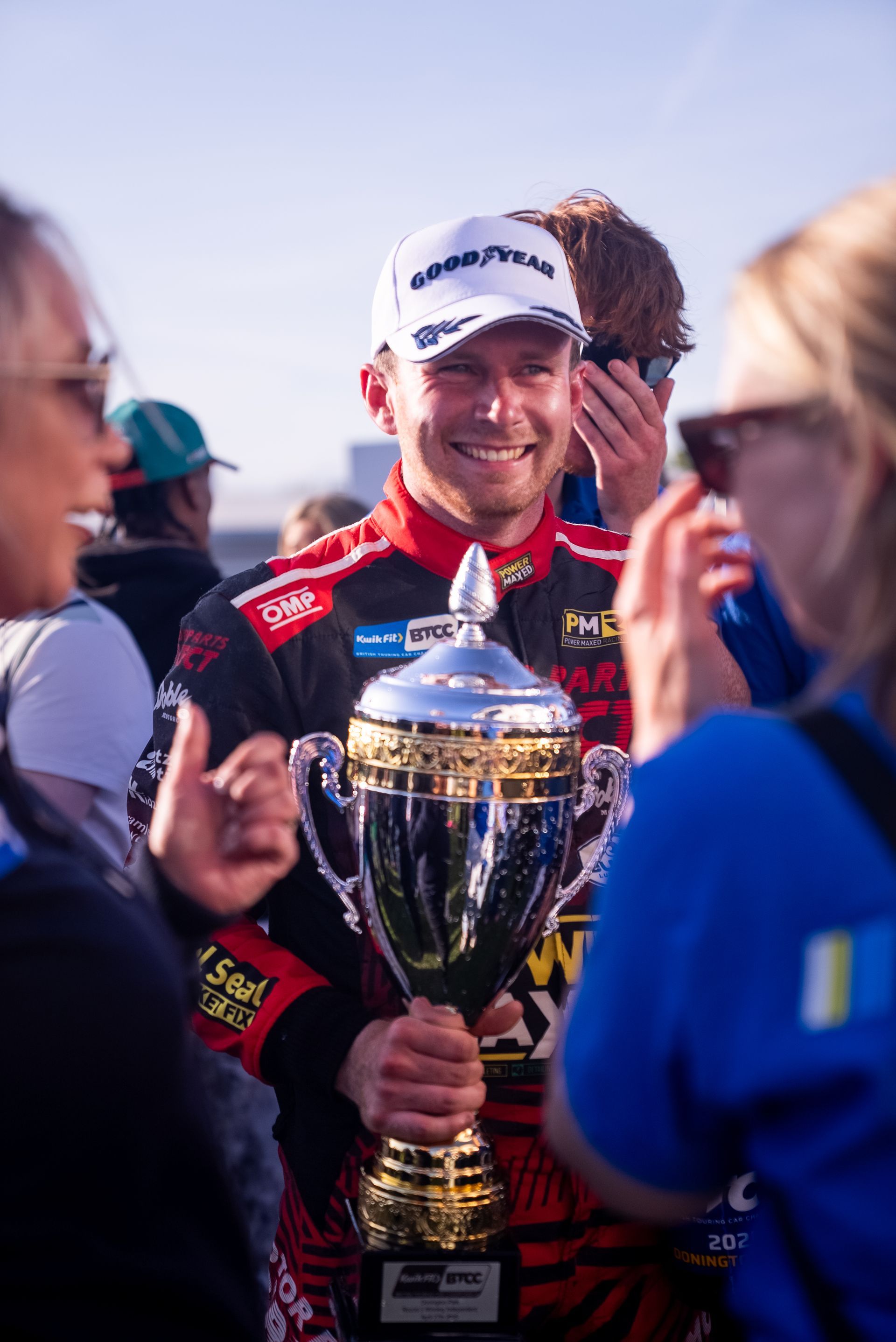 A man is holding a trophy in front of a crowd of people.