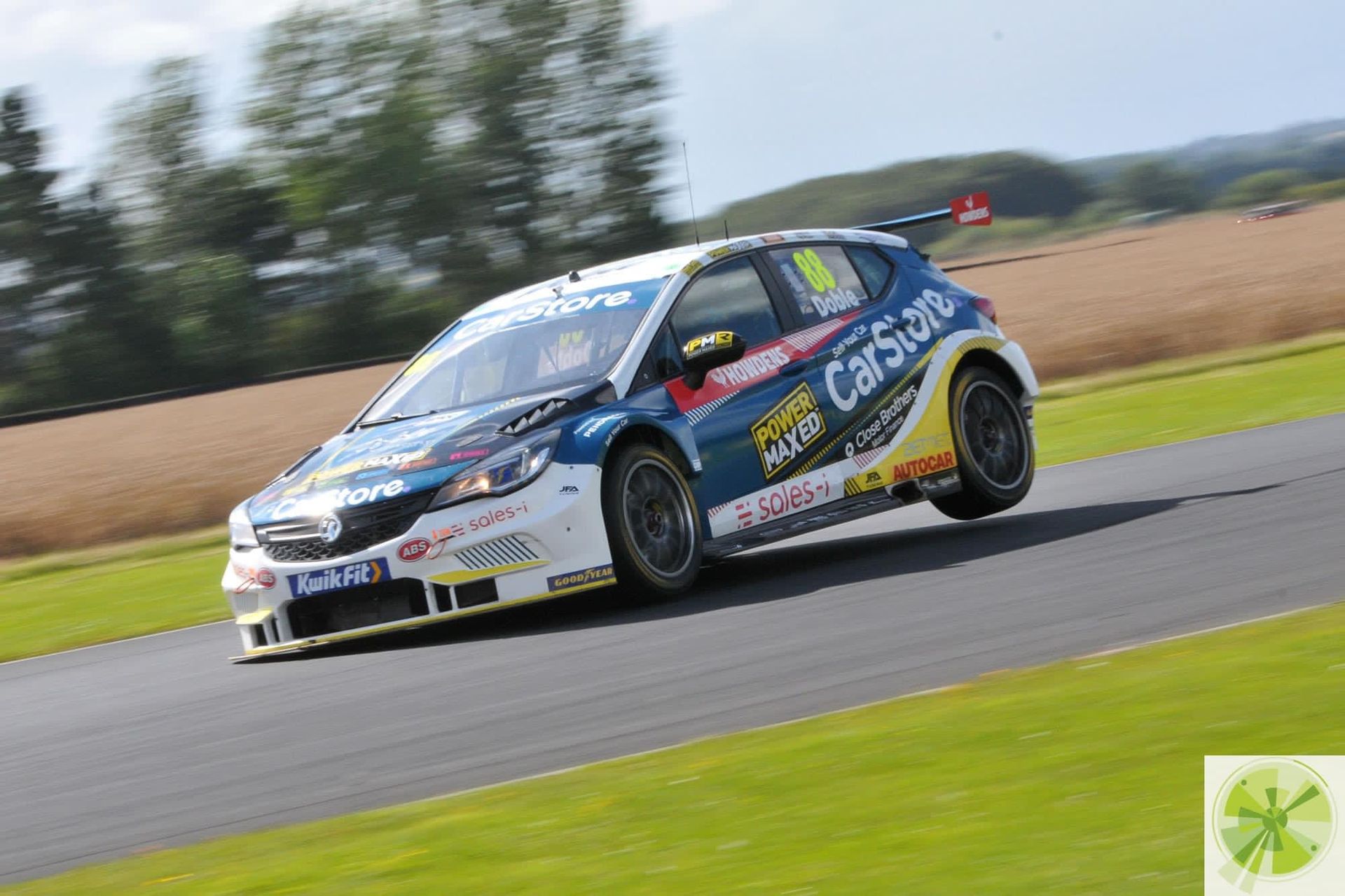 A blue and yellow race car is driving down a track.