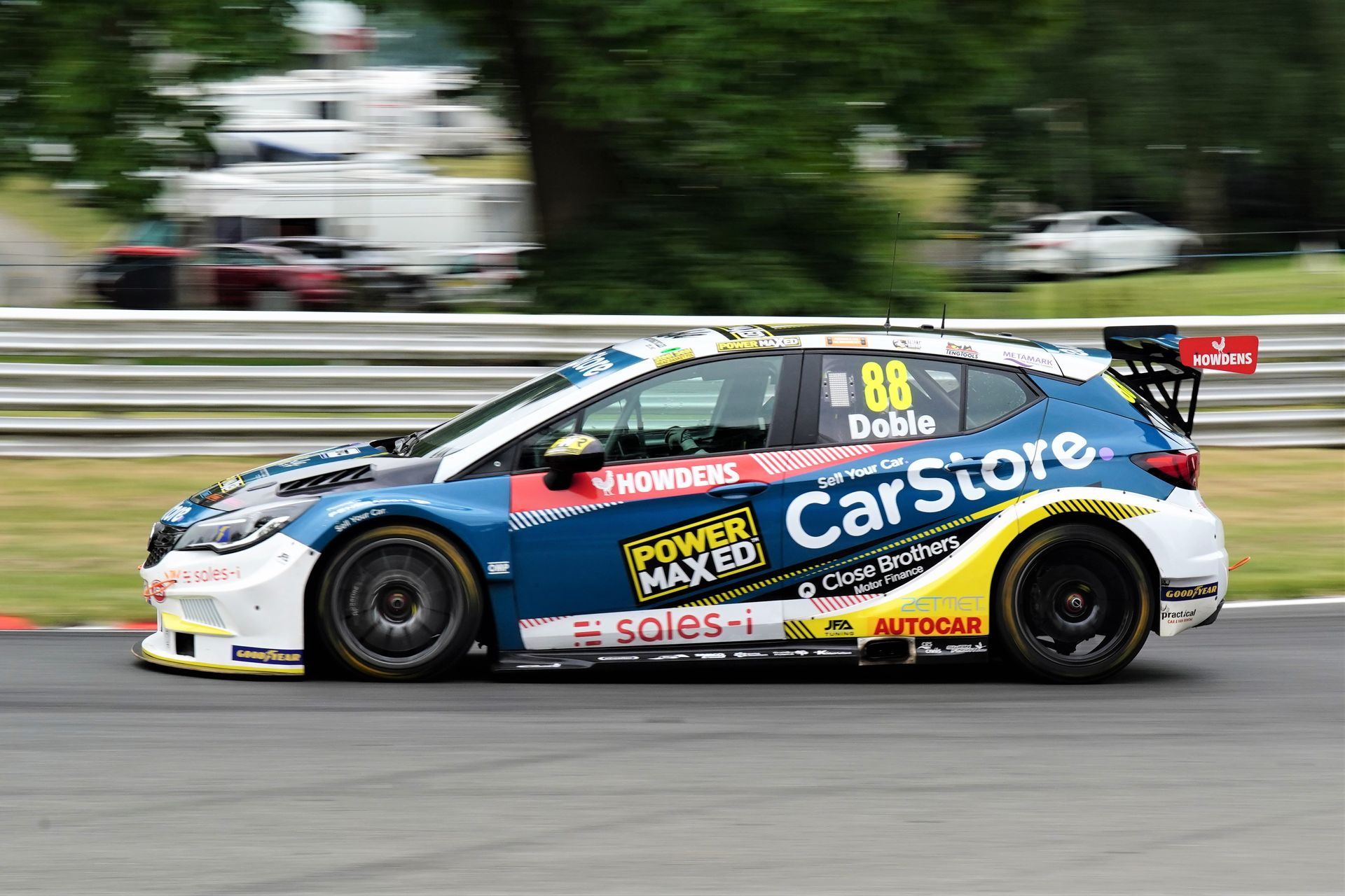 A blue and white race car is driving down a race track.