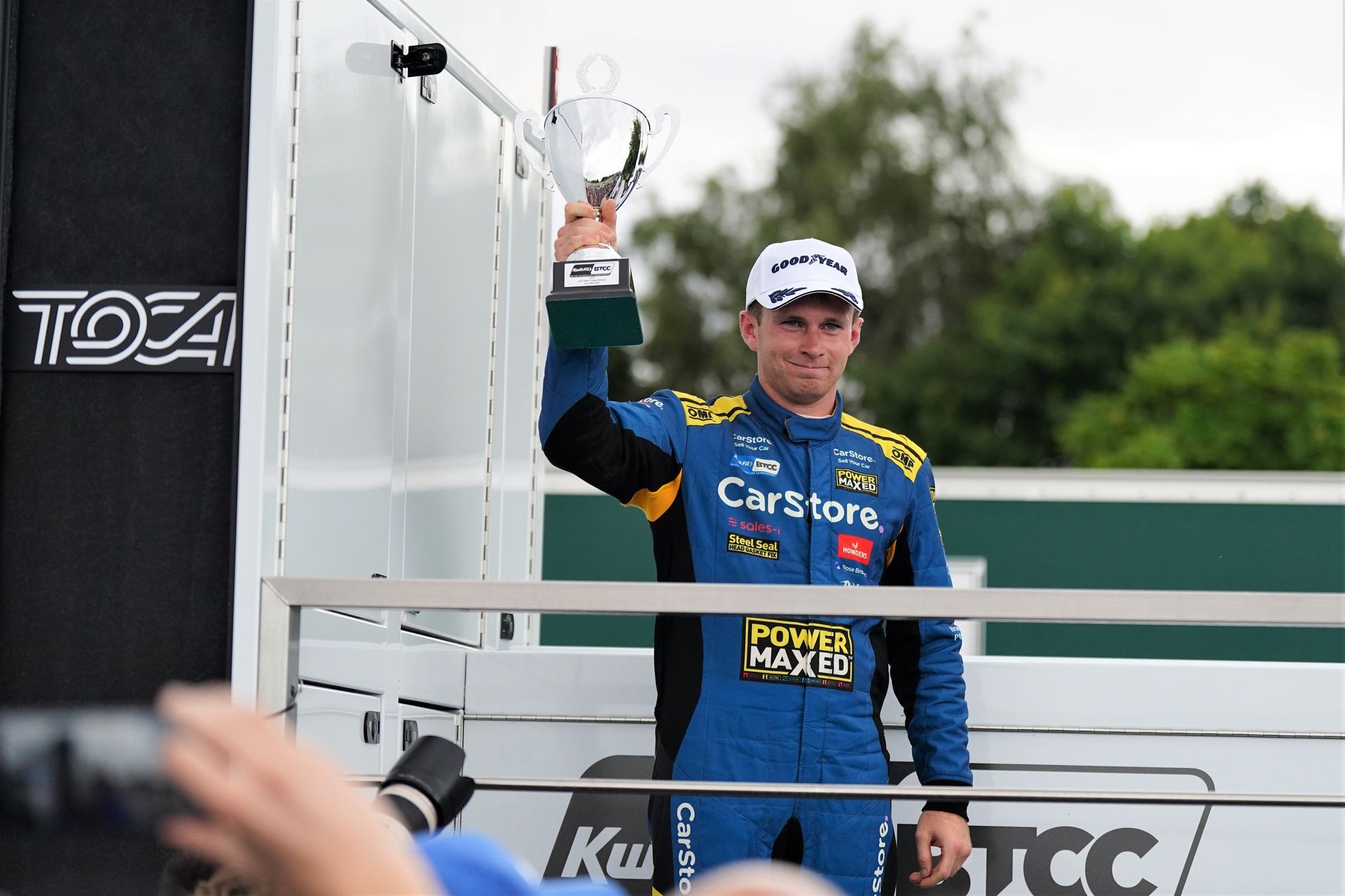 A man in a blue suit is holding a trophy in his hand.
