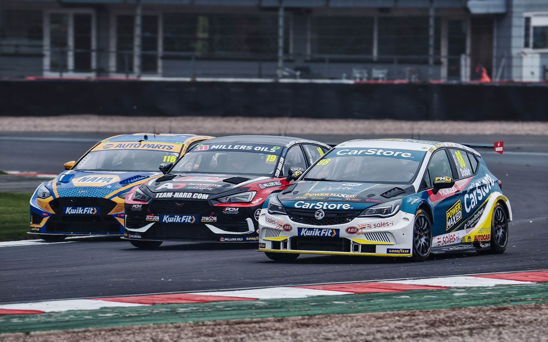 A group of racing cars are racing on a race track.