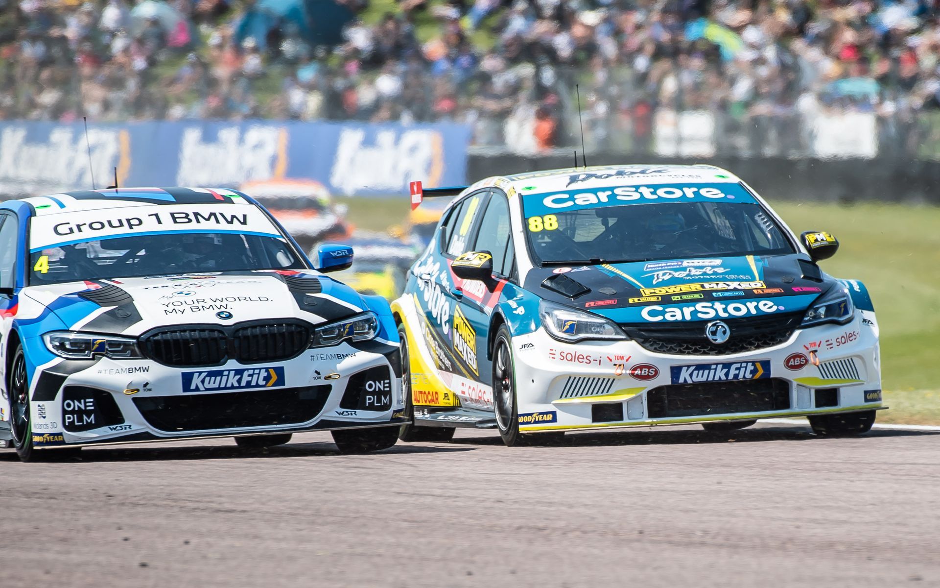 Two racing cars are racing on a race track.