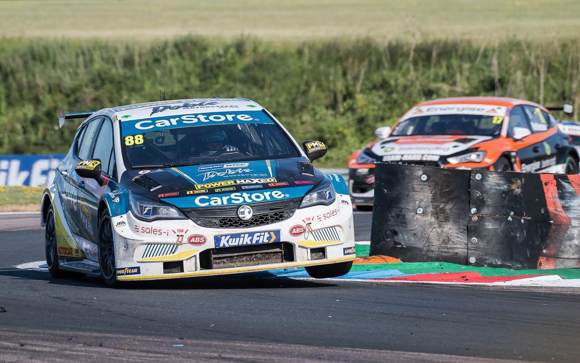 Two racing cars are racing on a race track.