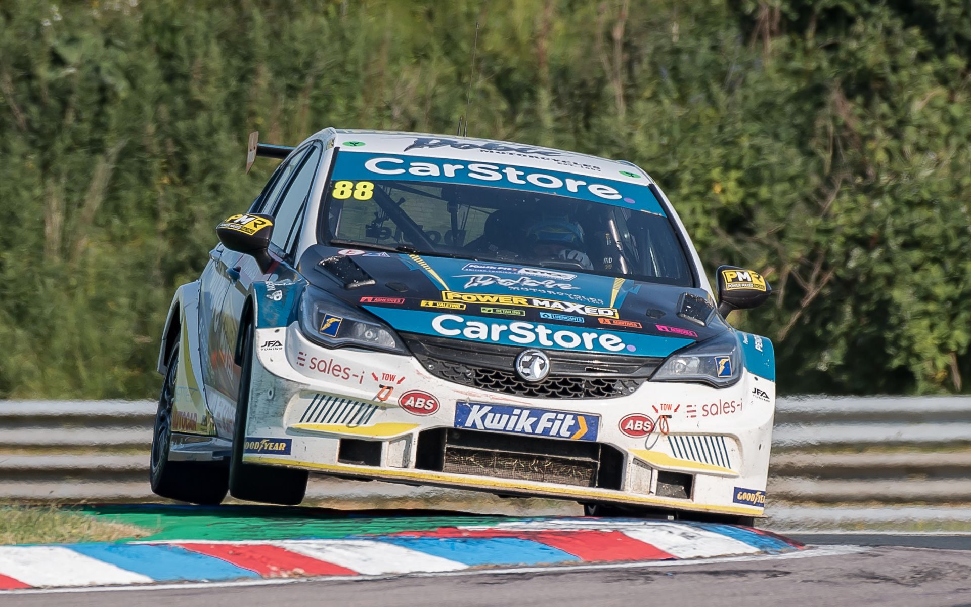 A race car is driving down a race track.