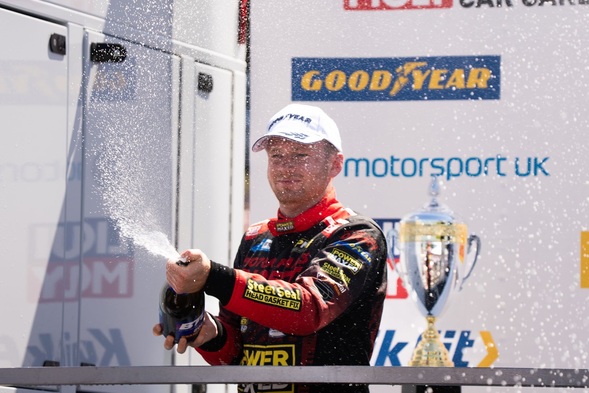 A man is standing in front of a good year sign