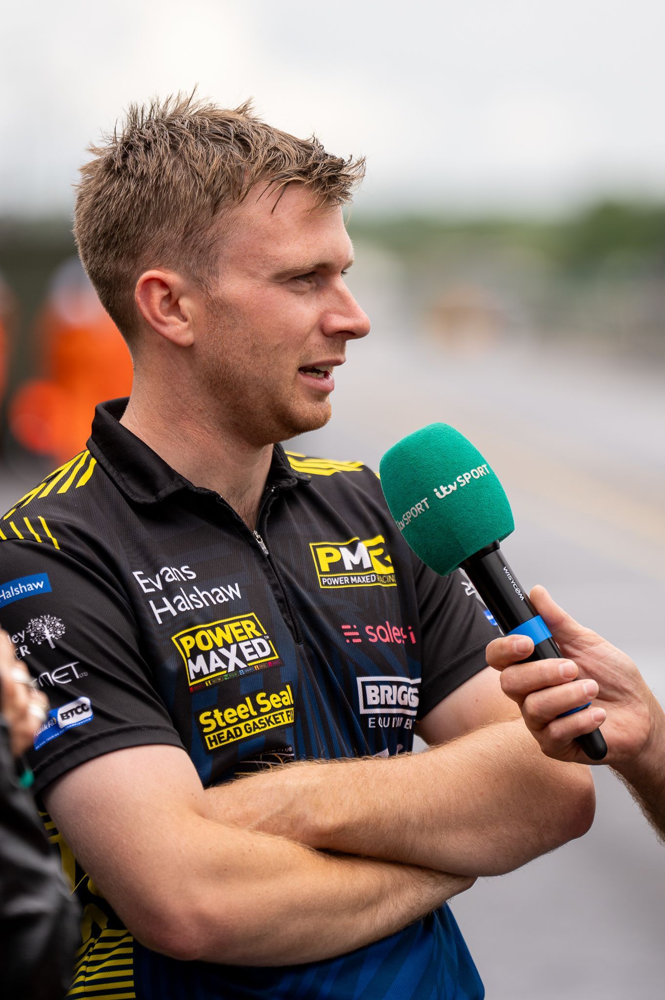 A man is being interviewed with a green microphone.