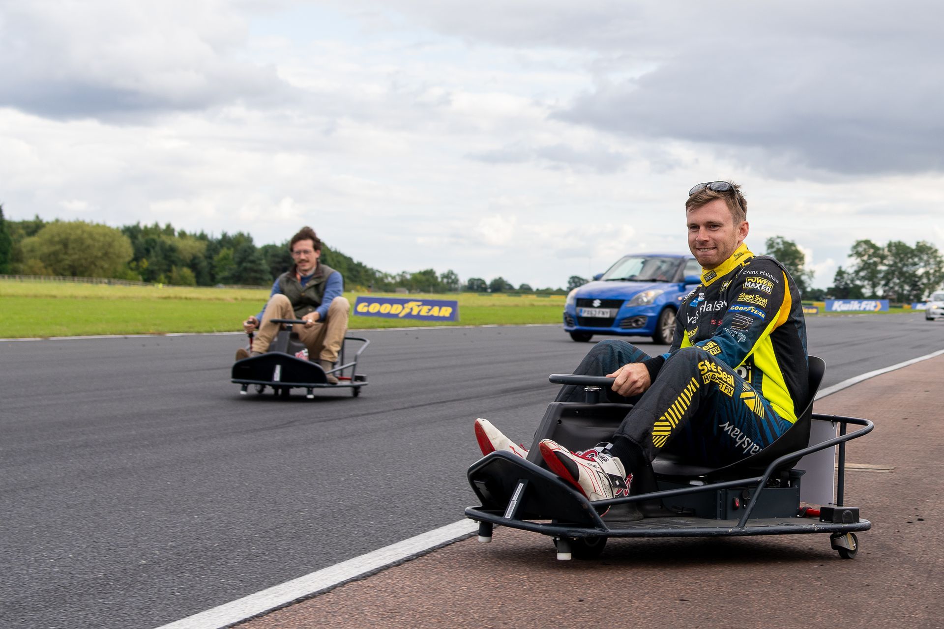 A man and a child are riding go karts on a track.