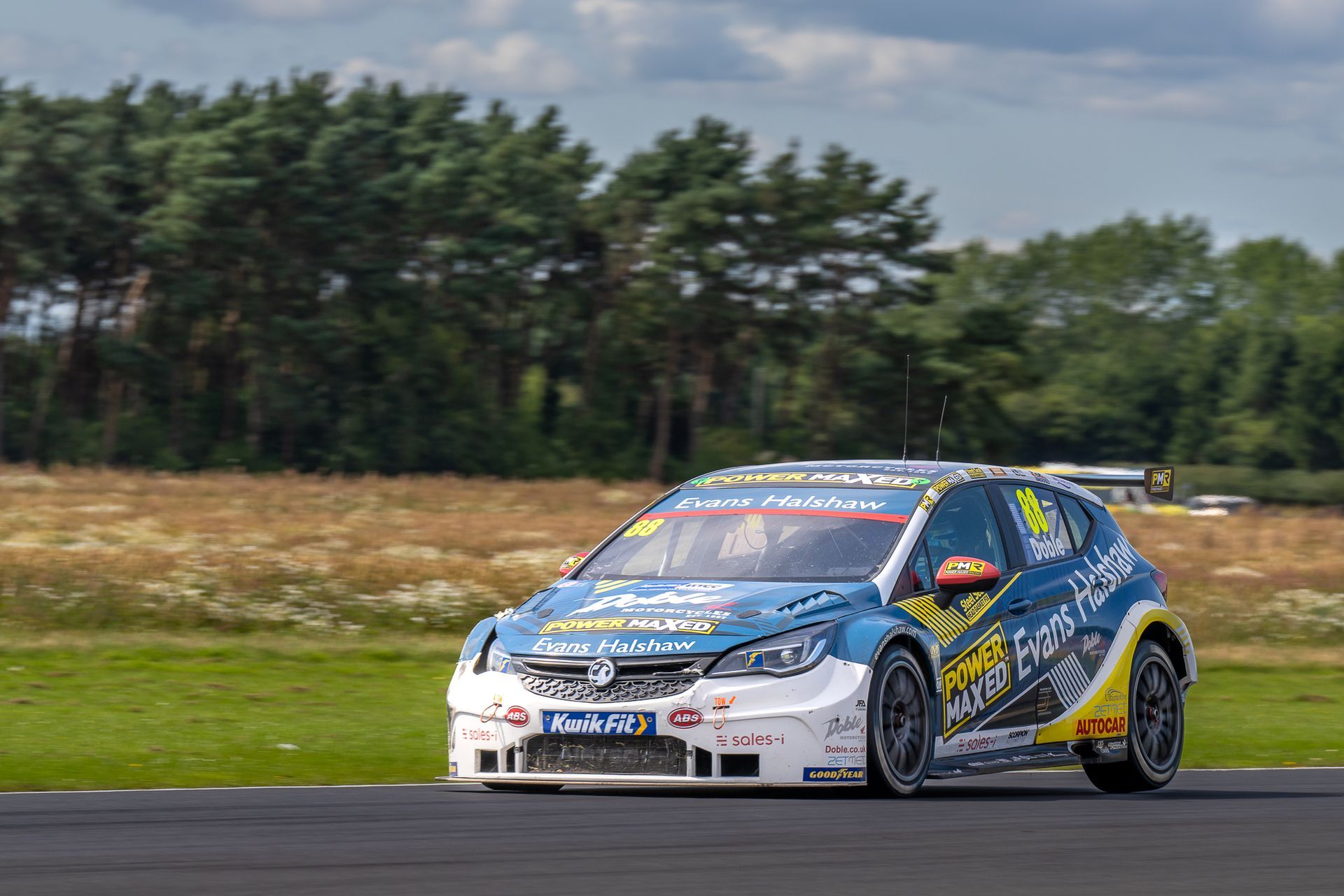 A blue and yellow race car is driving down a track.