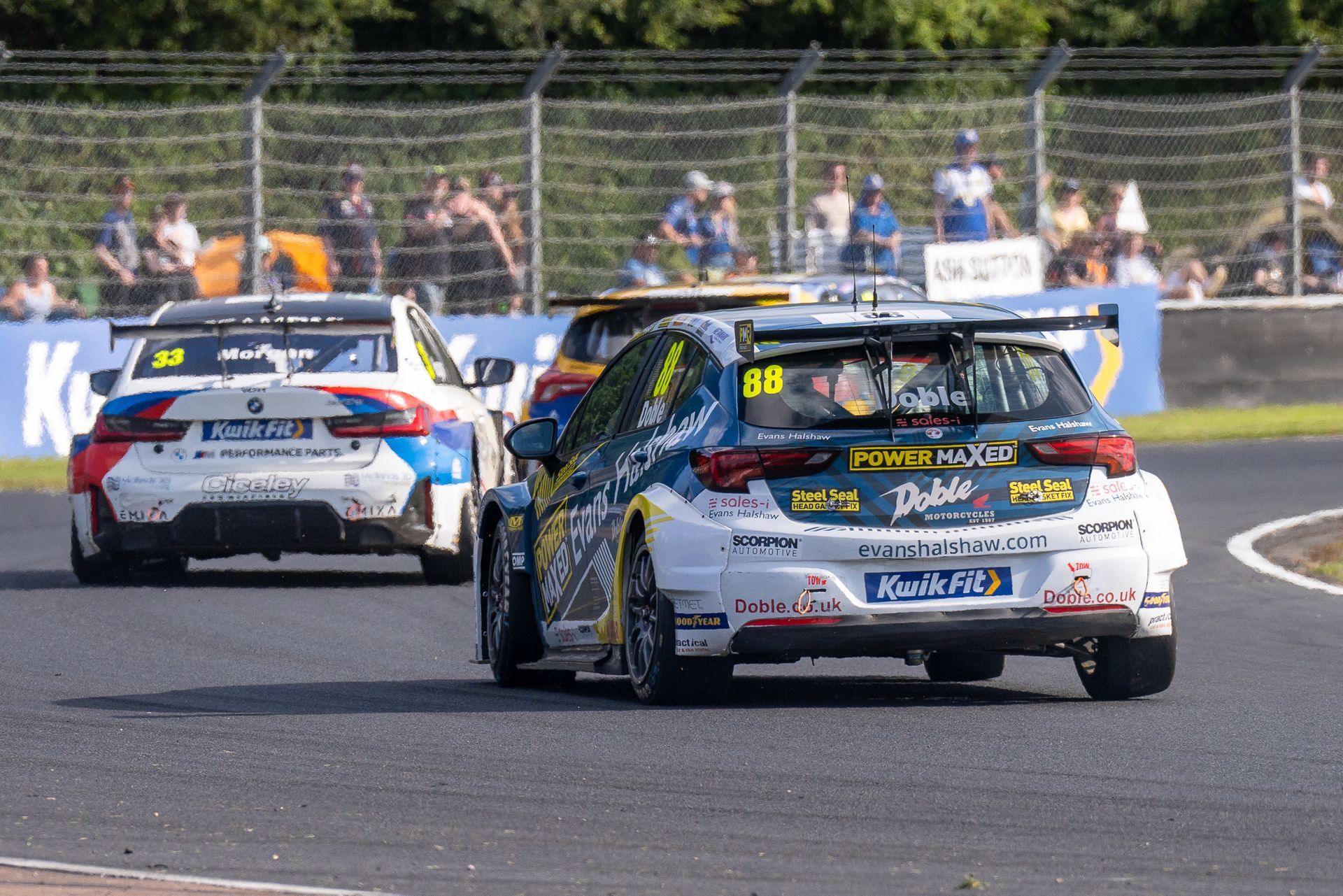 A group of cars are racing on a race track.