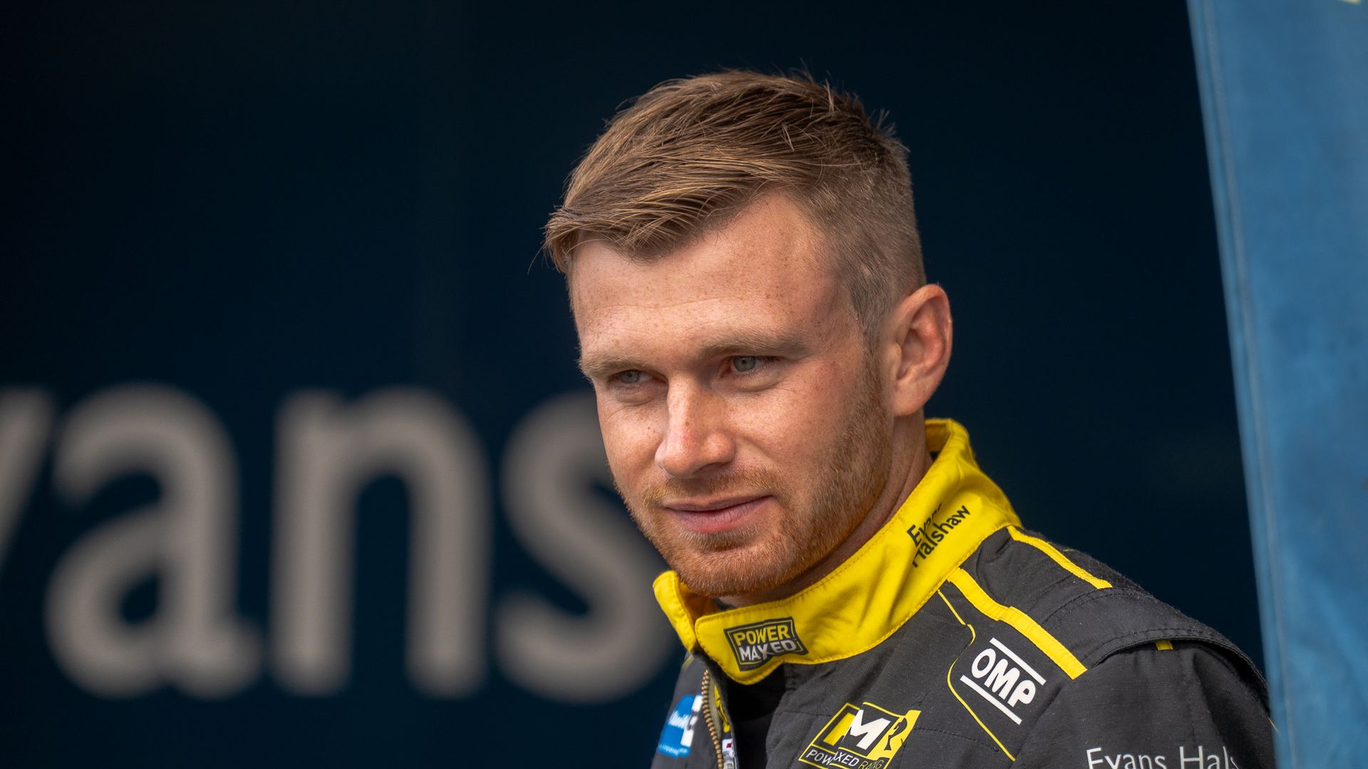 A man with a beard is wearing a black and yellow jacket.