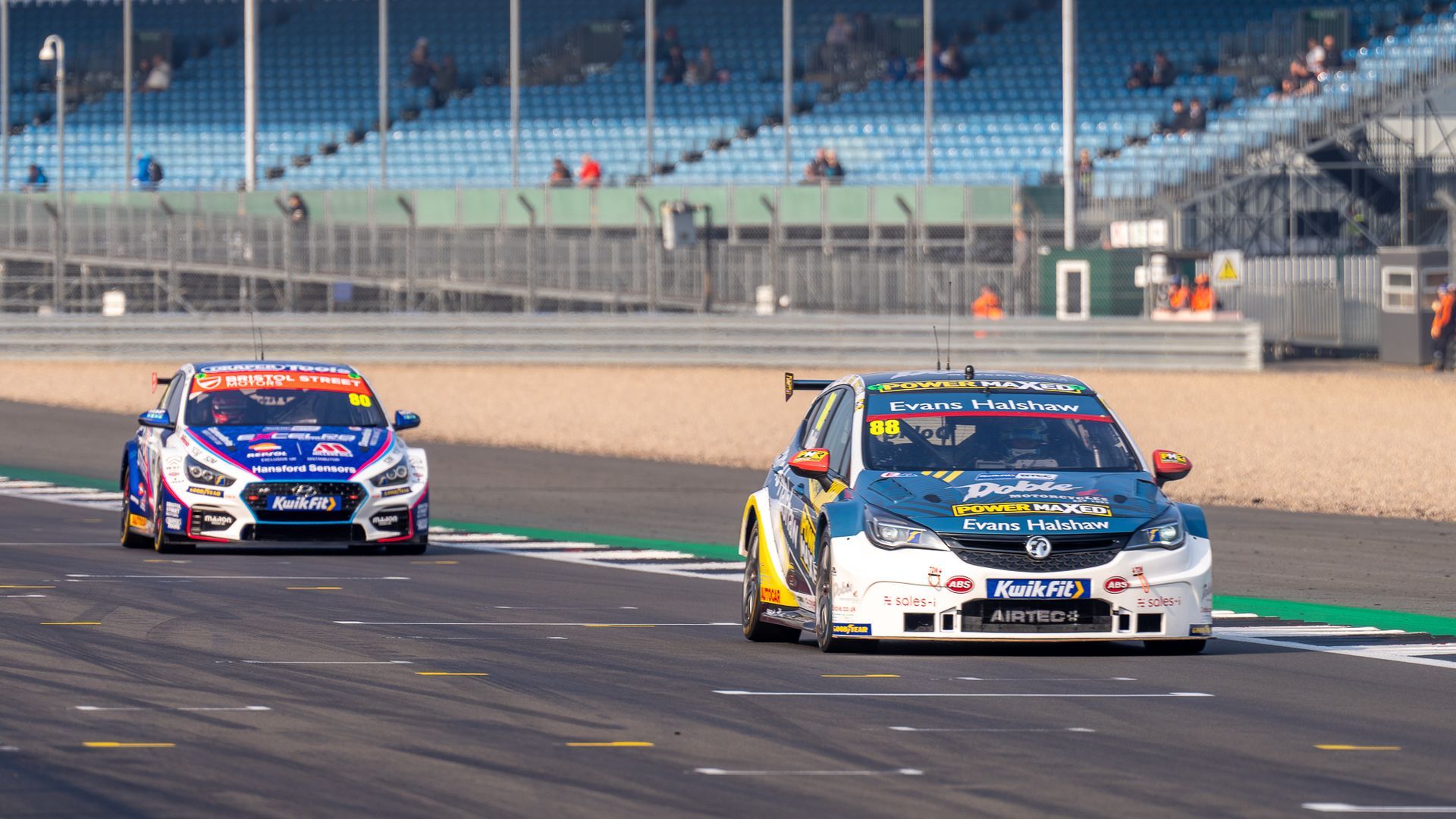 Two racing cars are racing on a race track.