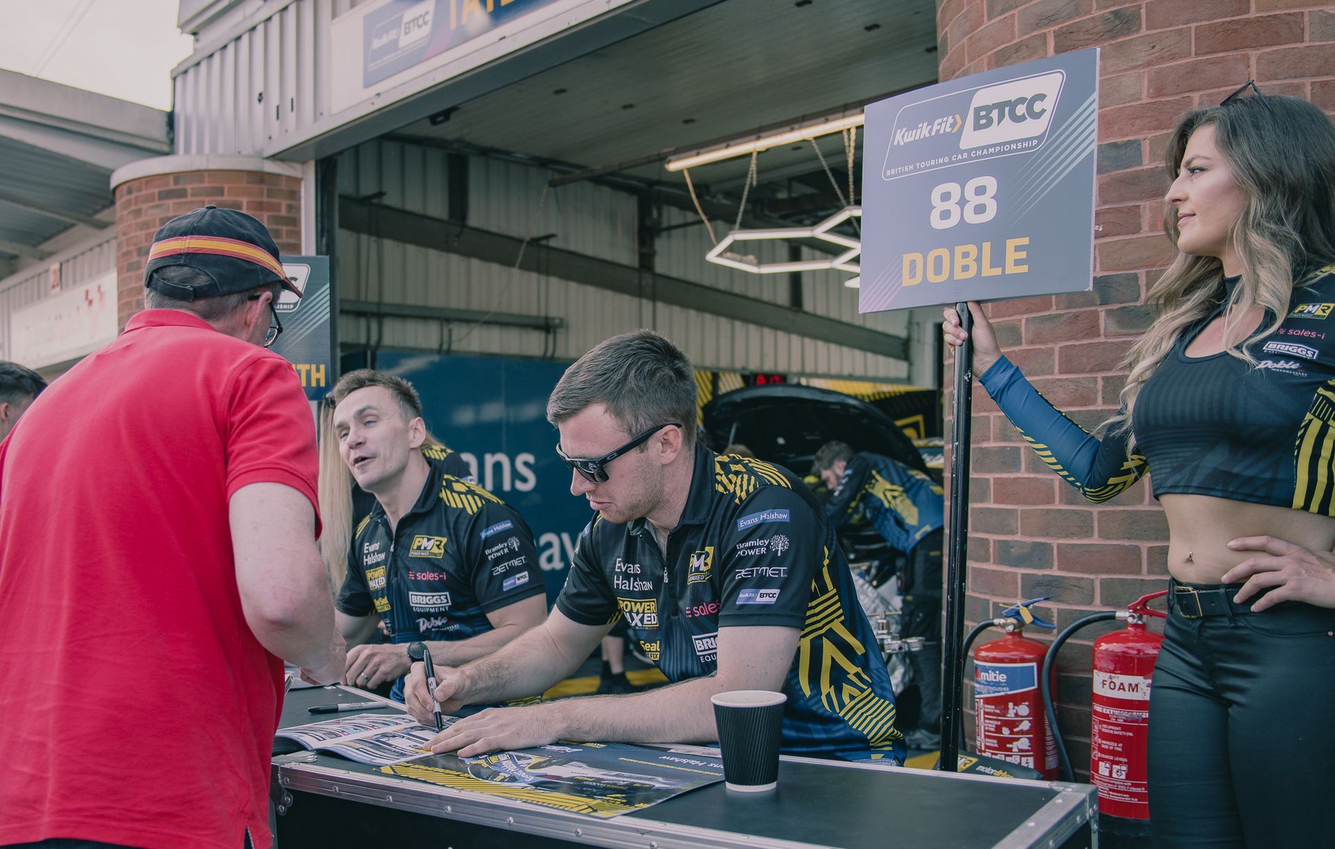 A group of people standing around a table with a sign that says `` doble ''.