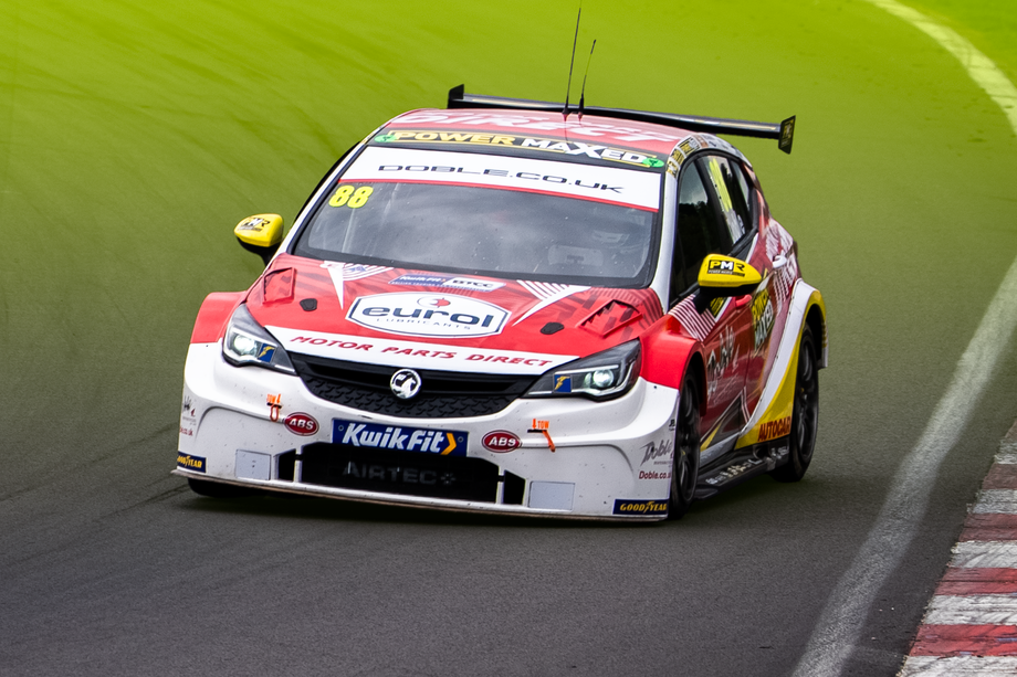 Mikey Doble racing around corner with Sponsors on front of car