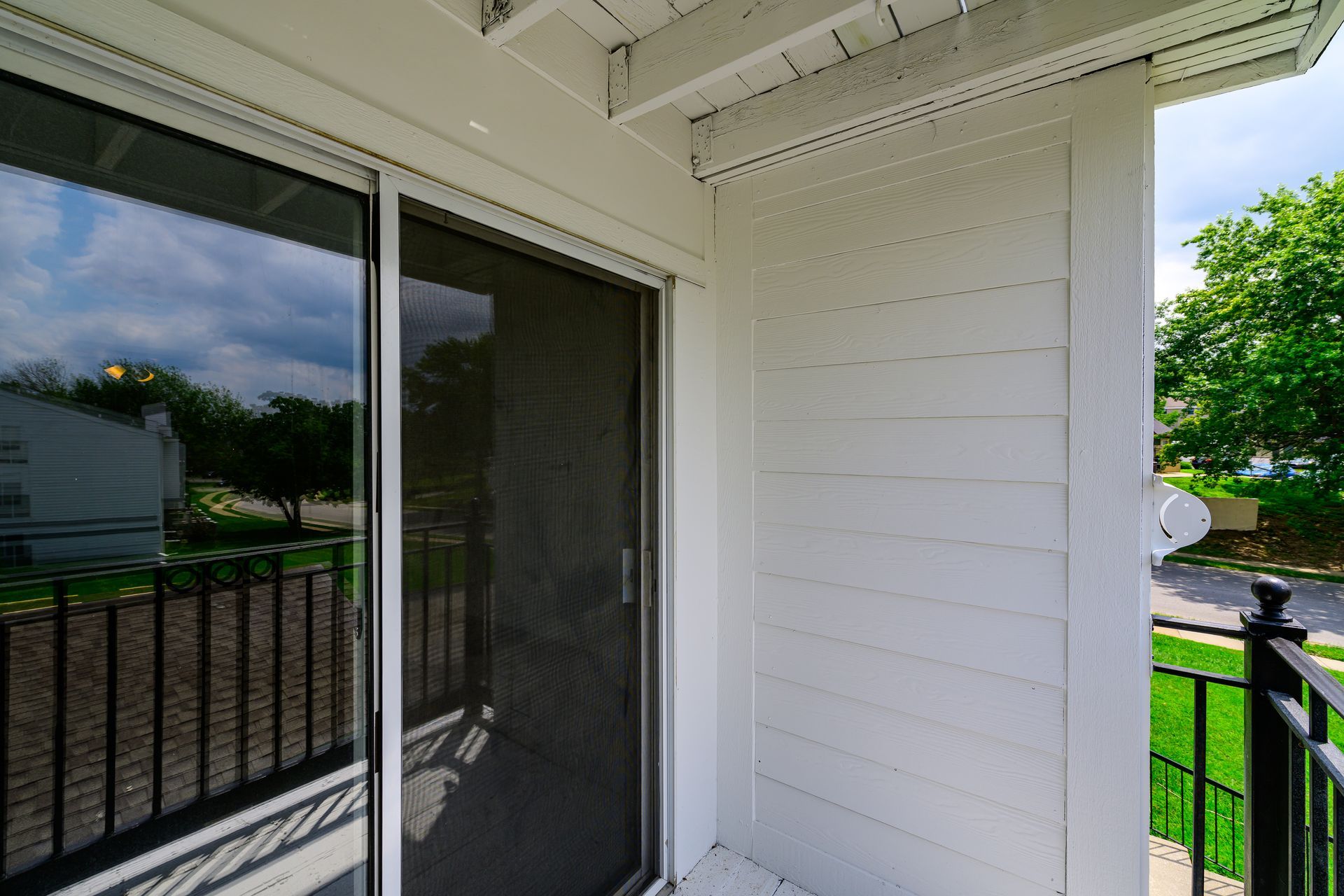 A white house with a sliding glass door and a railing.