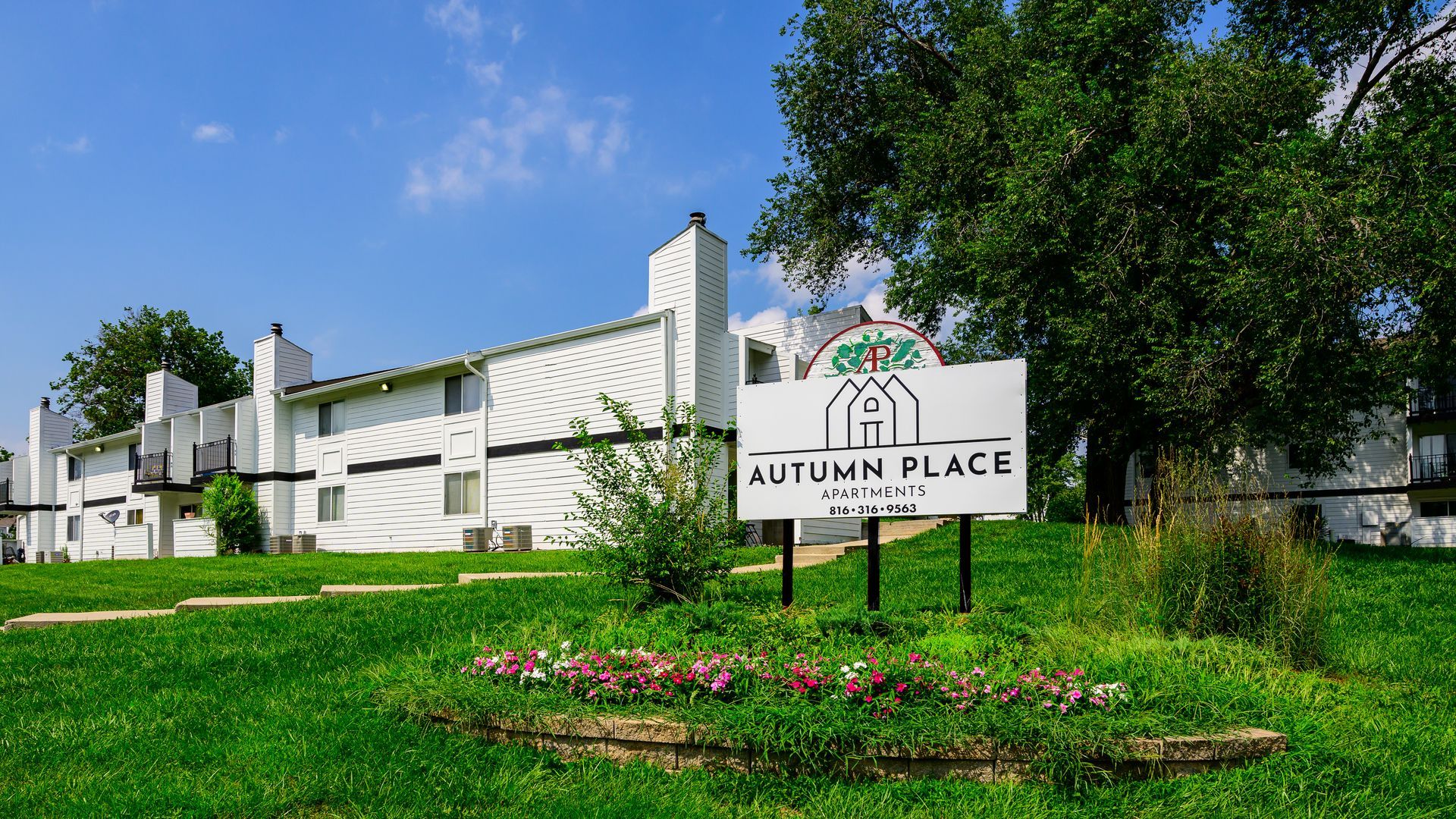 A white building with a sign in front of it.