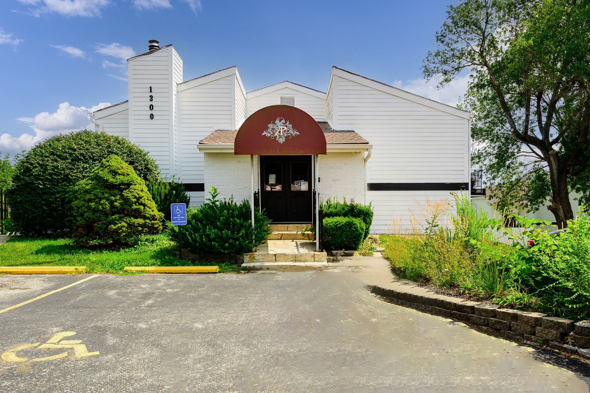 A white building with a red awning over the entrance