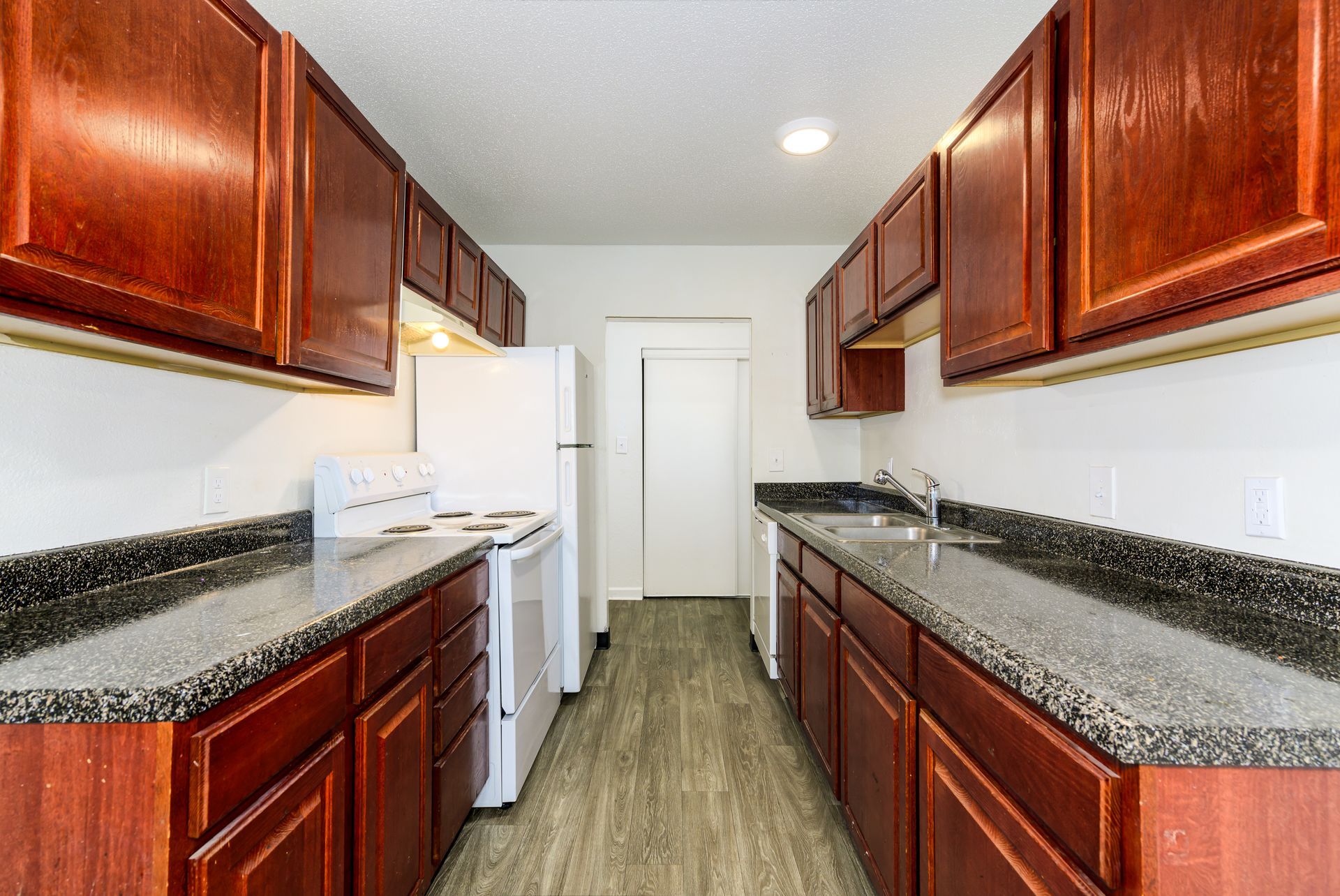A kitchen with wooden cabinets and granite counter tops.
