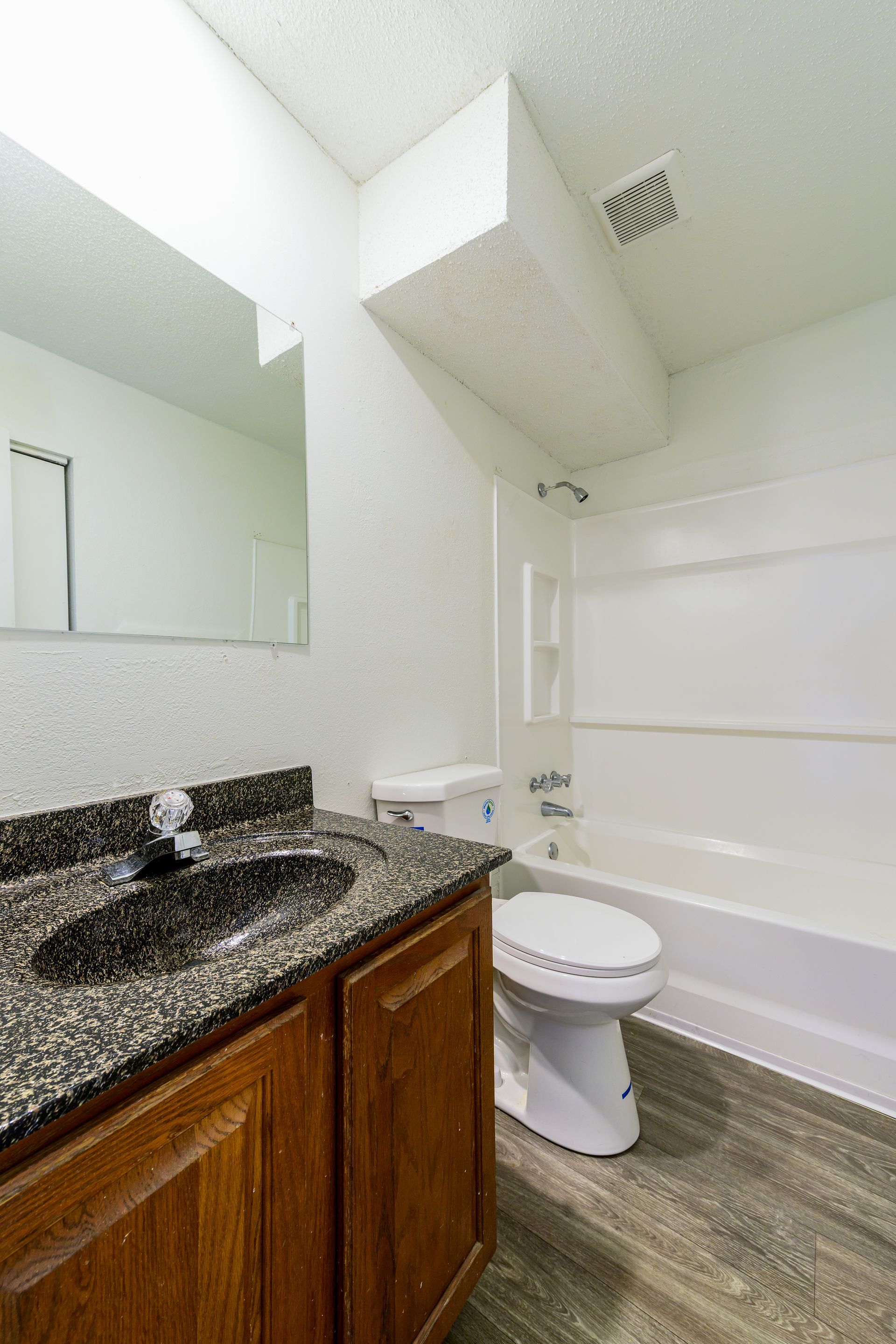 A bathroom with a sink , toilet , bathtub and mirror.
