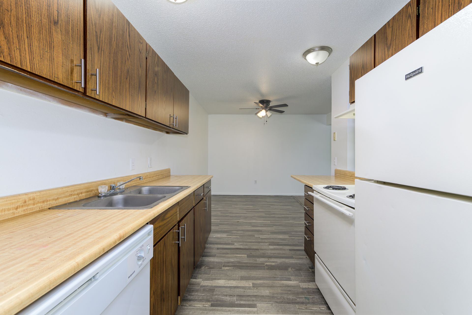 A kitchen with a sink , refrigerator , stove and dishwasher.