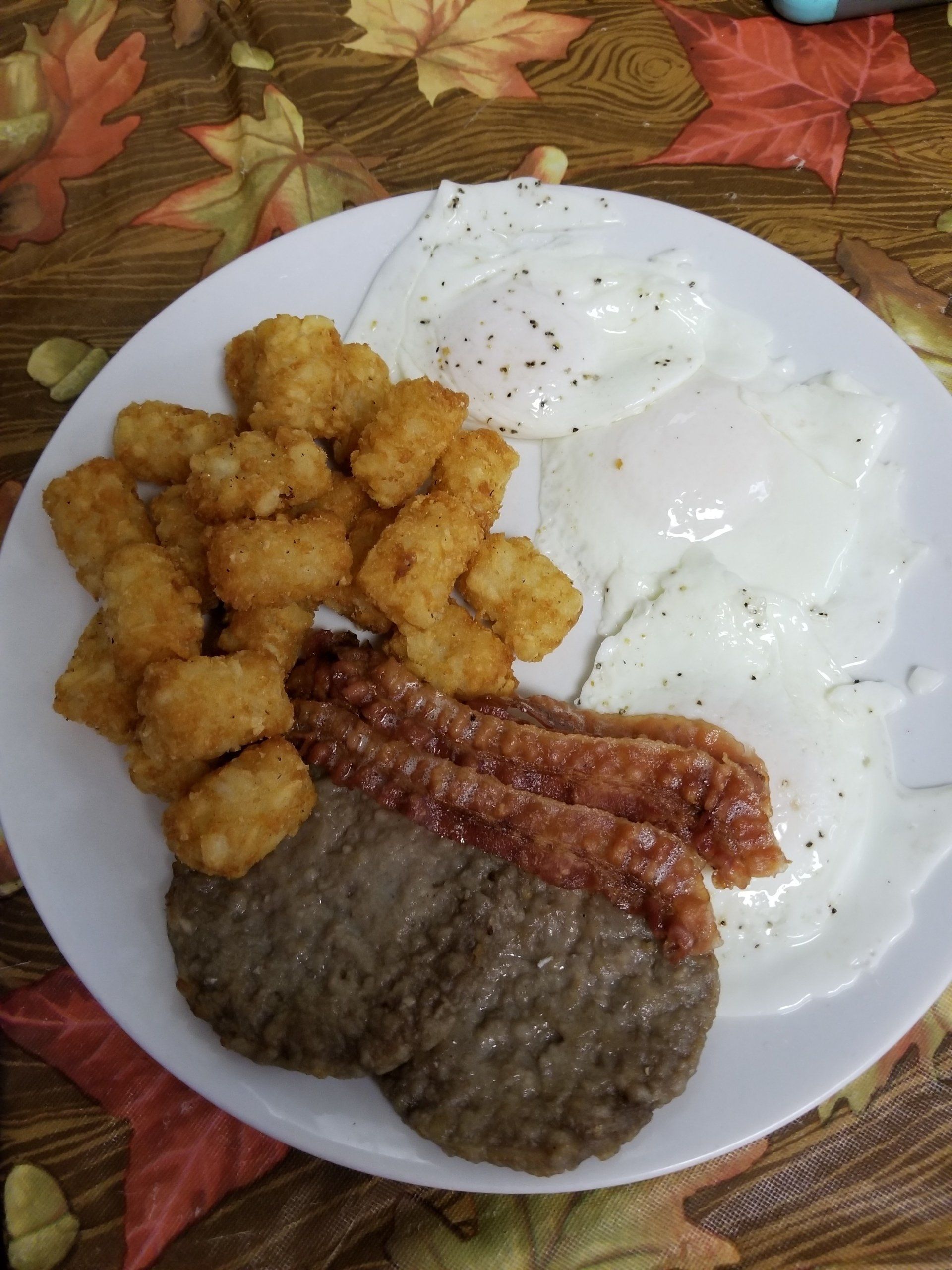 a white plate topped with eggs sausage and tots